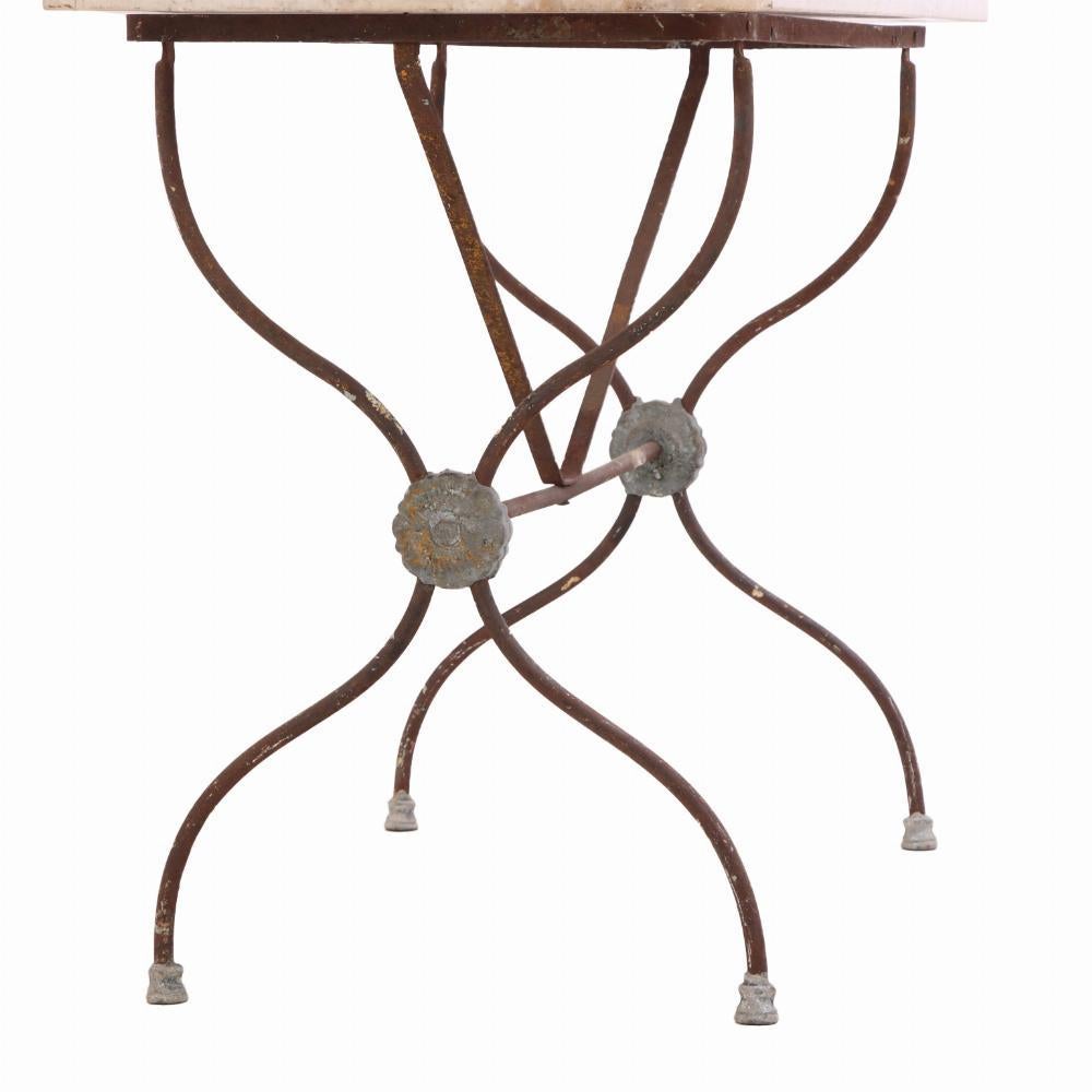 The weathered patina of the iron and subtle aging of the marble surface reflect the table's café provenance and early 20th-century character.

The zinc trim adds a utilitarian detail typical of French industrial design, while the crossed-leg iron
