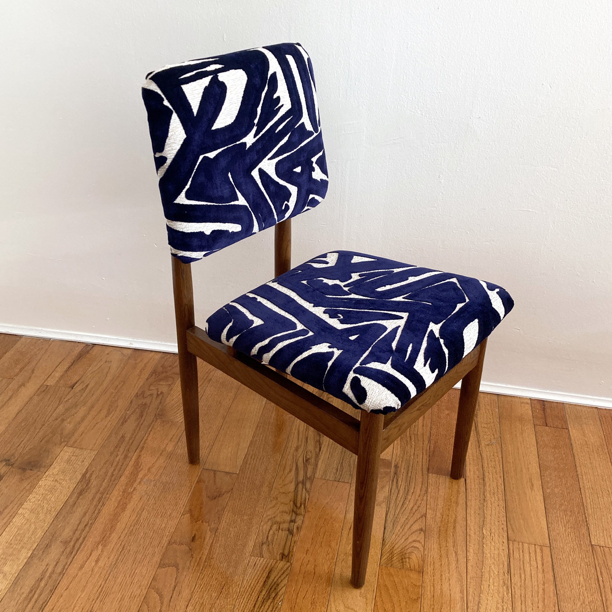 Beautiful midcentury chair, in the style of Arne Vodder. Oak frame, seat and back reupholstered with indigo and ecru fabric, the raised velvet indigo pattern absolutely glows. Structurally sound, comfortable.

In good vintage condition, minor
