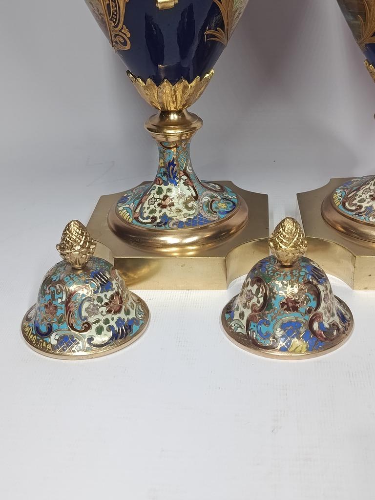 Elegant pair of Sèvres-style porcelain vases, crafted in France circa 1900, Napoleon III These vases are finely hand-painted with detailed gallant scenes on the front and landscapes on the reverse, enriched with cloisonné enamel and gilt bronze