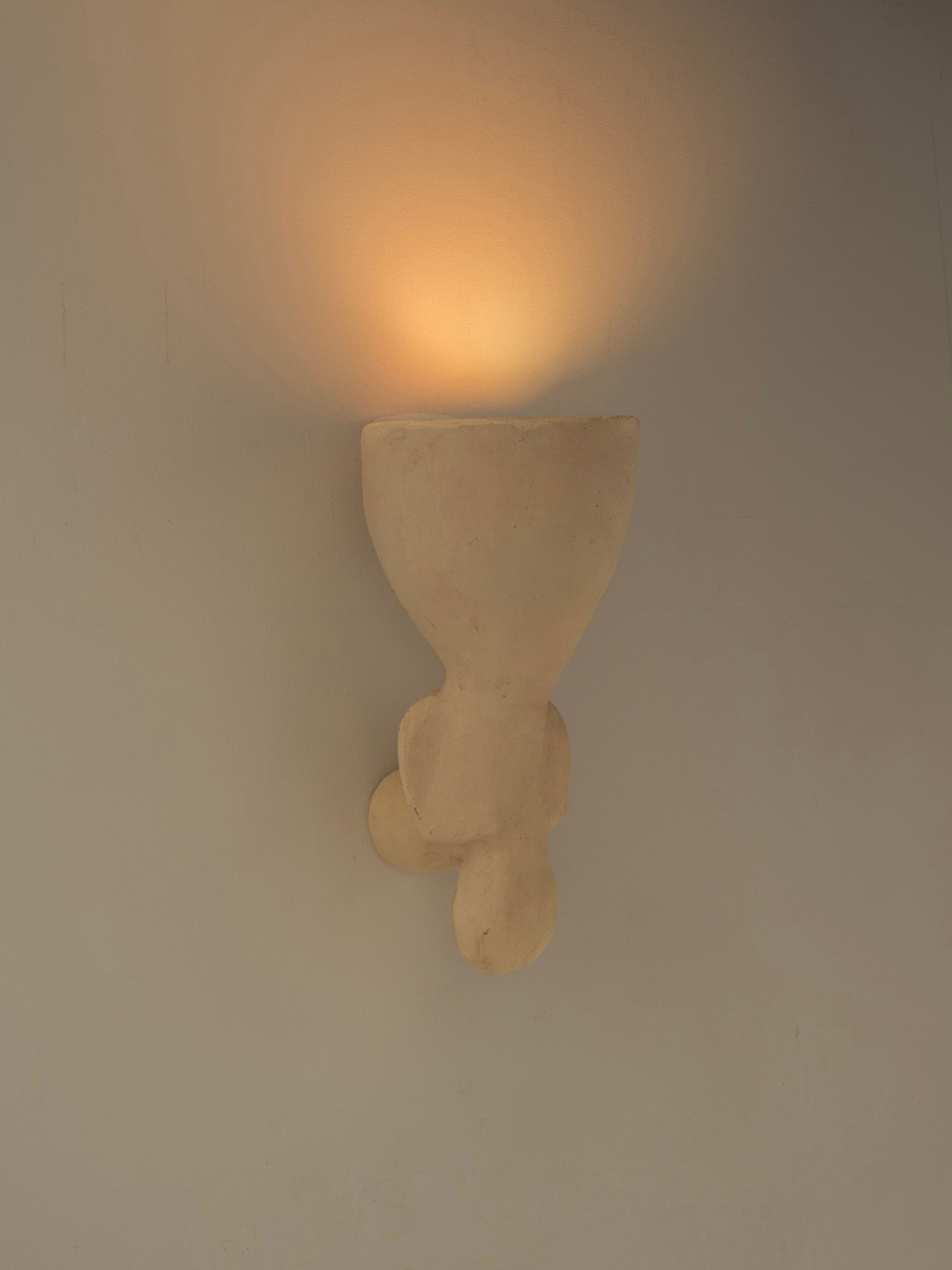 Lampada da parete in ceramica contemporanea di colore bianco, realizzata in argilla locale e lavorata a mano.