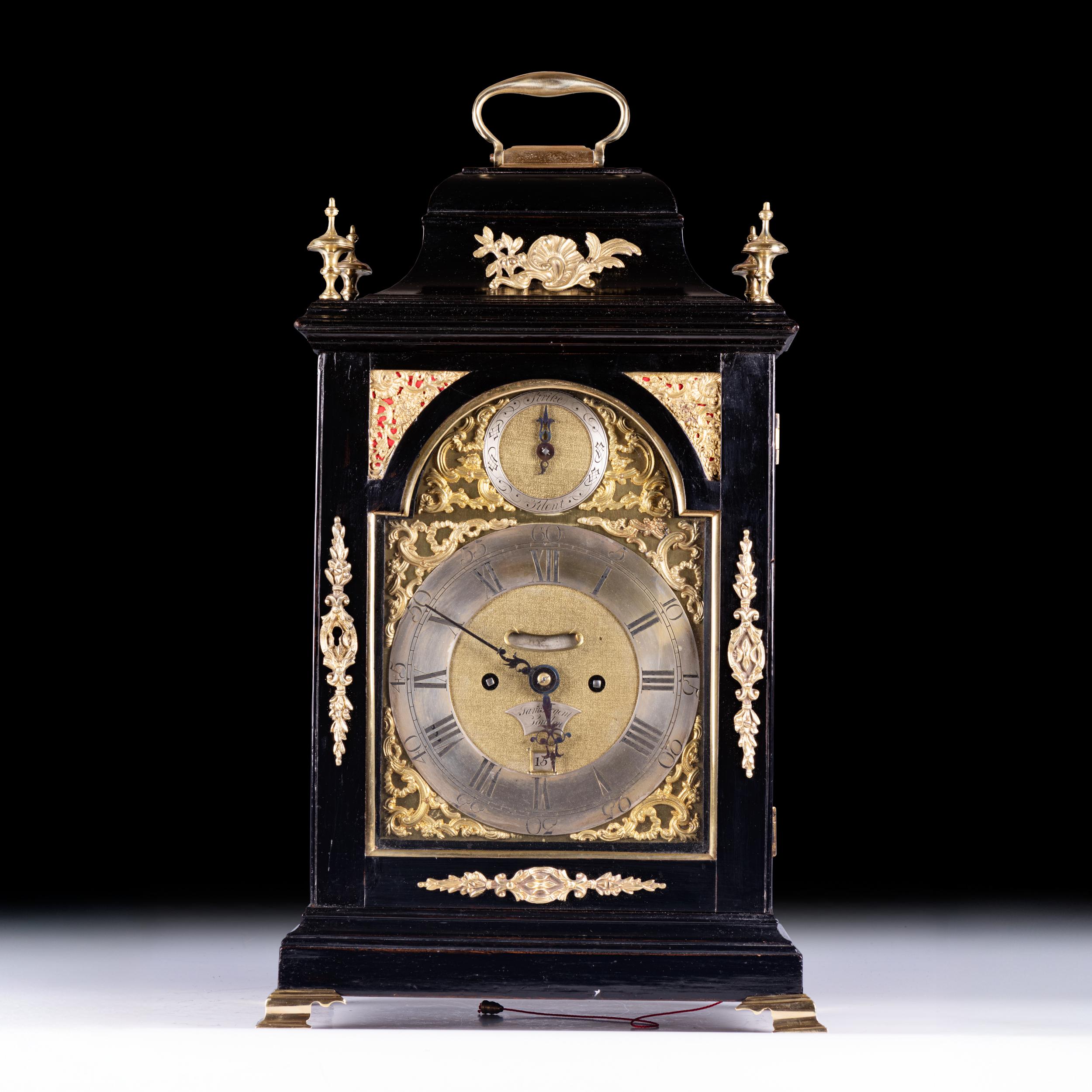 A fine late 18th-century English George III bracket clock, signed Sam Tregent, London. The ebonised case is surmounted by a brass carrying handle and adorned with cast gilt bronze floral and scroll mounts to the sides, corners, and base. The arched