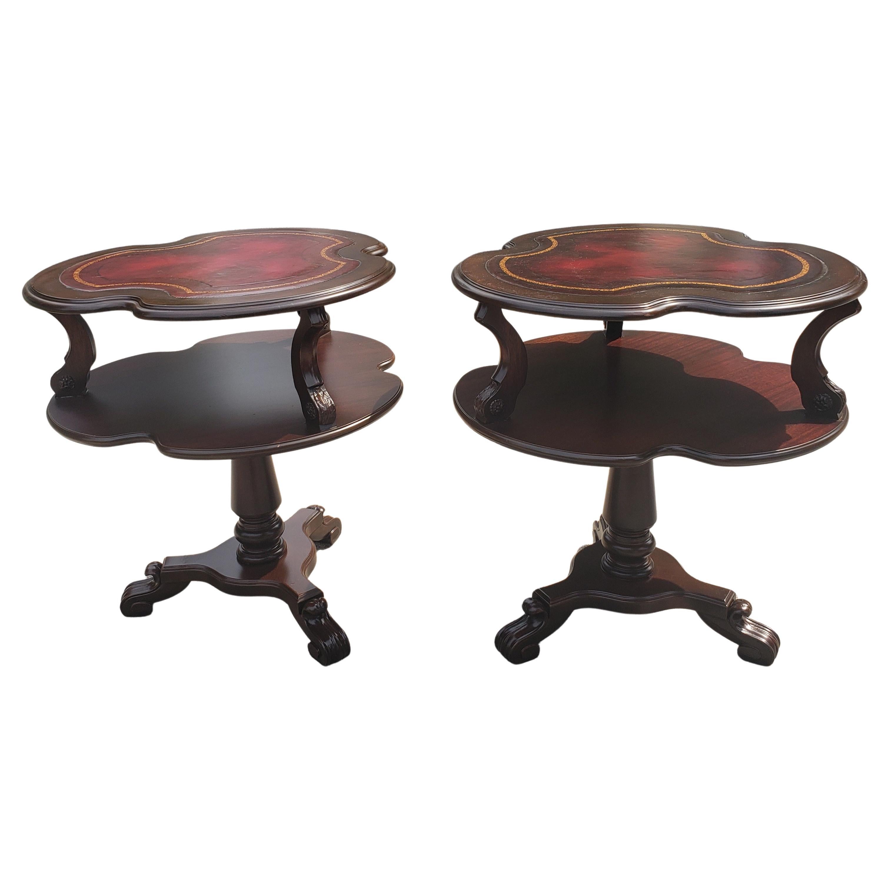 Stunning, refinished English Regency two-tier maroon leather top insert side tables. Pedestal Tripod legs terminating with paw feet. Just been professionally refinished, with antiqued used leather top insert preserved. Leather gold Stenciling in