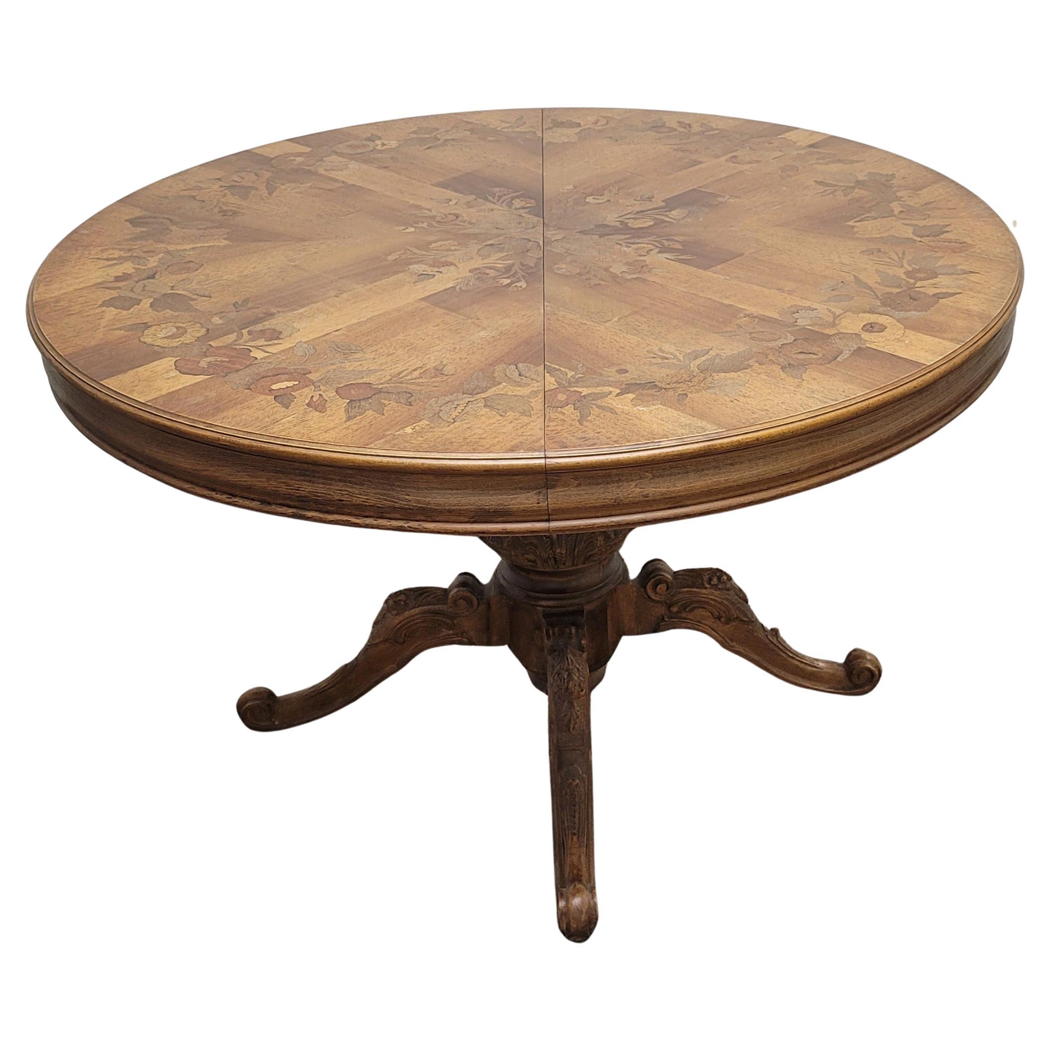 A beautiful French made Provincial marquetry mixed fruitwood Inlaid pedestal oval or round breakfast / dining table in great condition. Pedestal with amazing hand carvings over four (4) equally carved feet. Shows great. Intricate marquetry work on