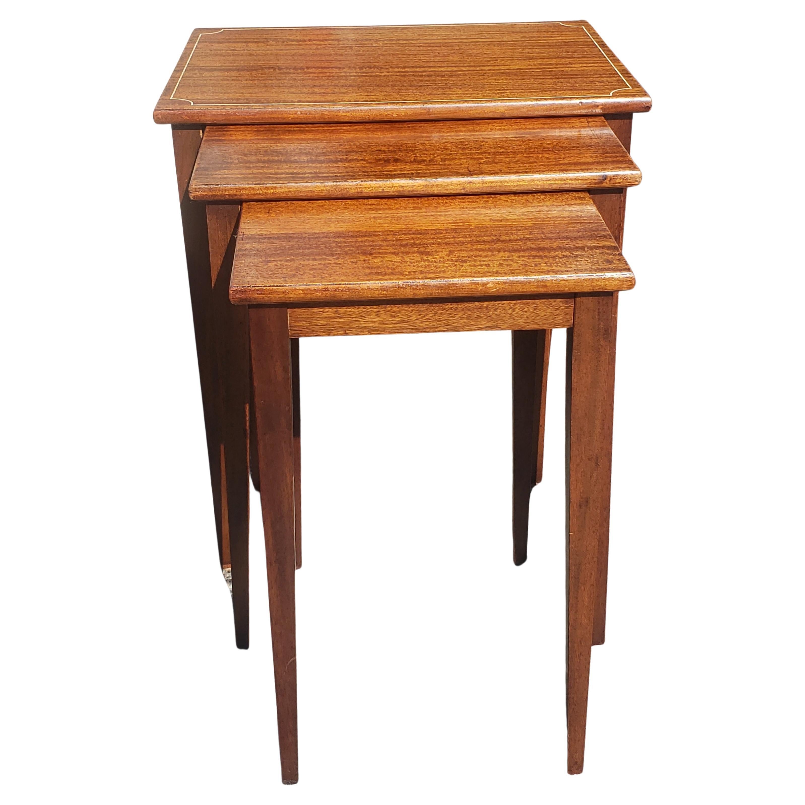 A fully refinished set of three 1950s Brandt Fine Furniture  Genuine Mahogany Nesting Tables. Largest table measures 24