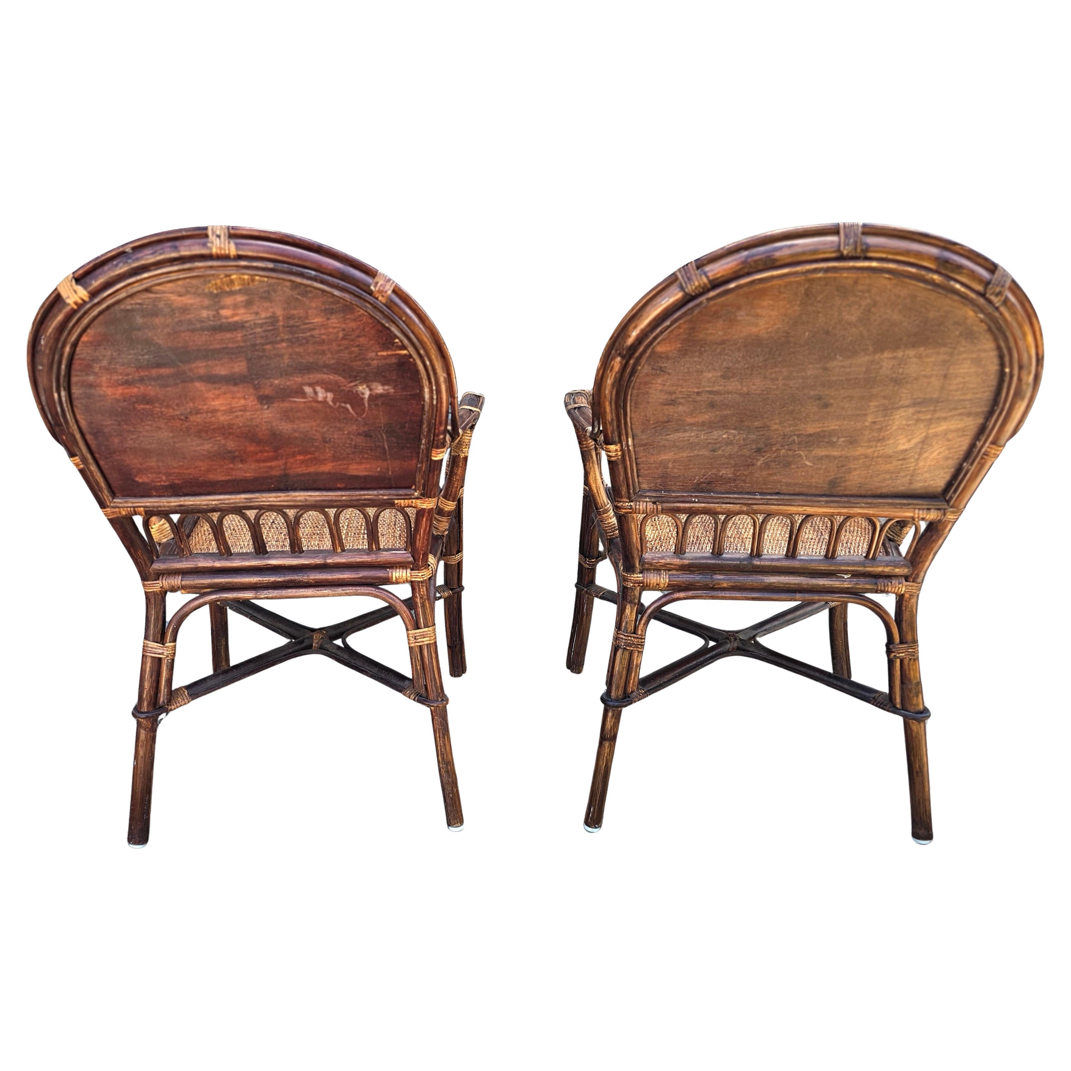 Paire de fauteuils du milieu du siècle en rotin et à dossier rembourré en roseau tressé brun. 
Mesure 