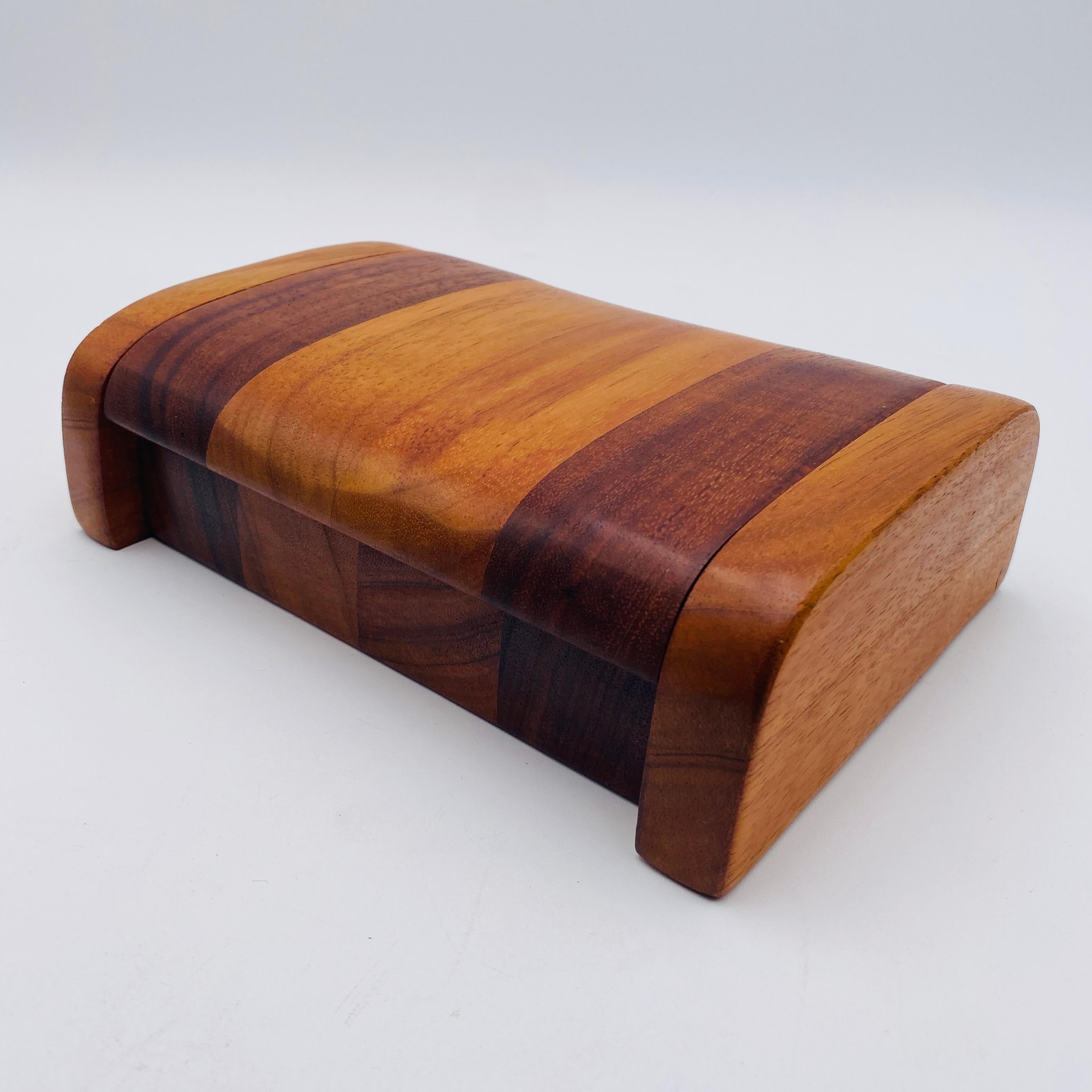 A beautiful box hand-crafted from Hawaiian Koa by the infamous artist Po Shun Leong. The box is perfect for storing jewelry since the interior is lined. The lid opens and closes easily. The bottom of the box is hand signed and dated, 