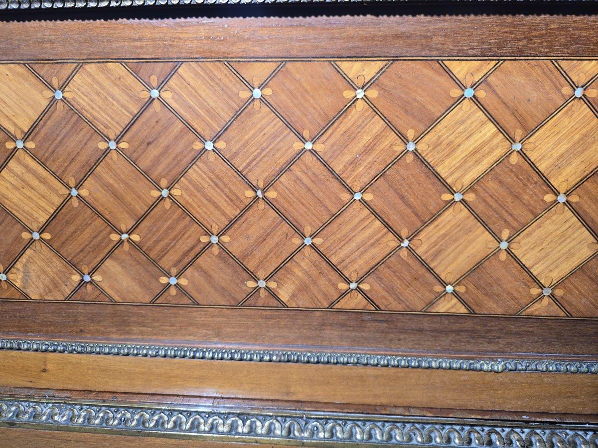 Elegante vetrina francese del XIX secolo realizzata in legno pregiato finemente intarsiato con motivi geometrici esotici, intarsiato con madreperla e riccamente ornato con bronzo dorato.

La parte anteriore presenta un'ampia lastra di vetro curvo,