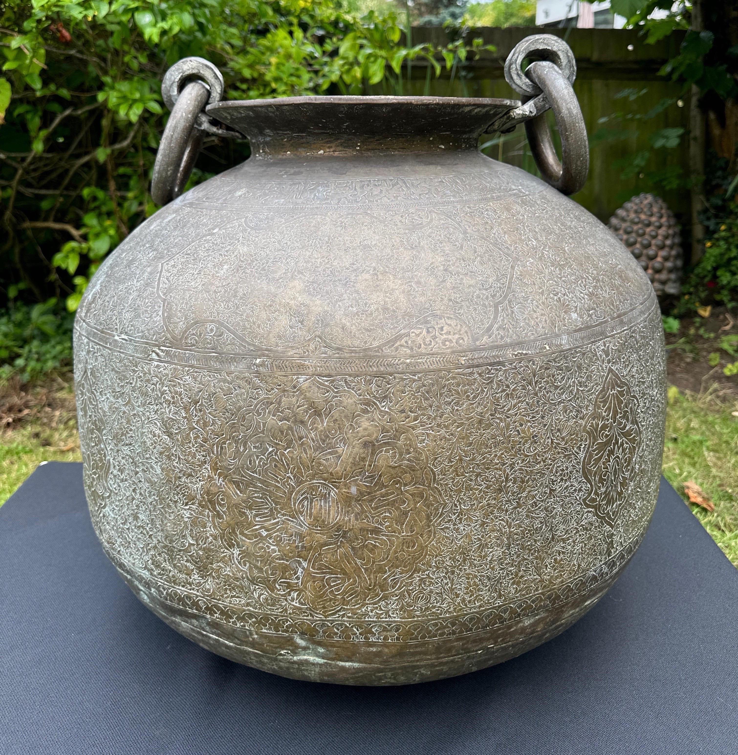A wonderful Cyrian bronze urn, handmade in the Middle East with engravings around the whole of the urn. With beautiful circular solid bronze handles. Some age related dents . 
Possibly used for carrying water.