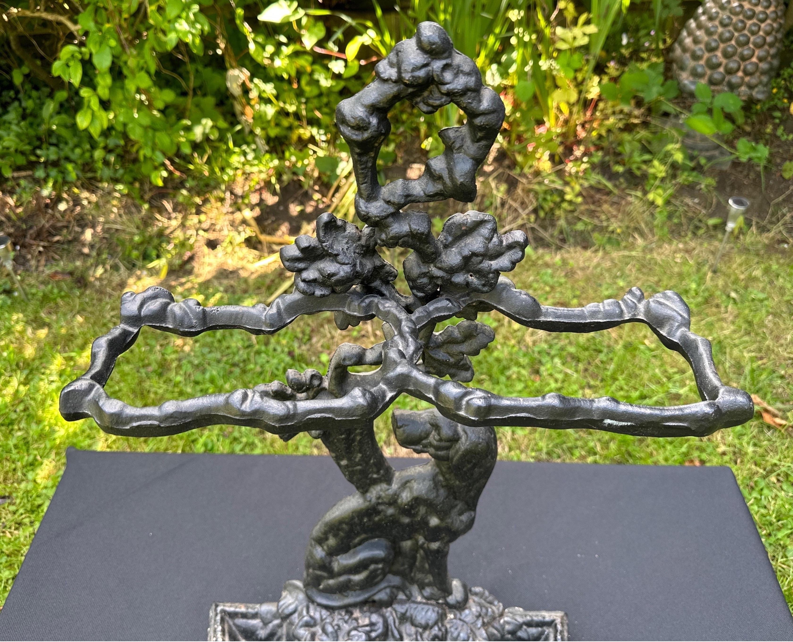 A wonderful cast iron stick stand , picturing a lovely dog, and featuring acorns and foliage, tapering onto a circular cast base. 