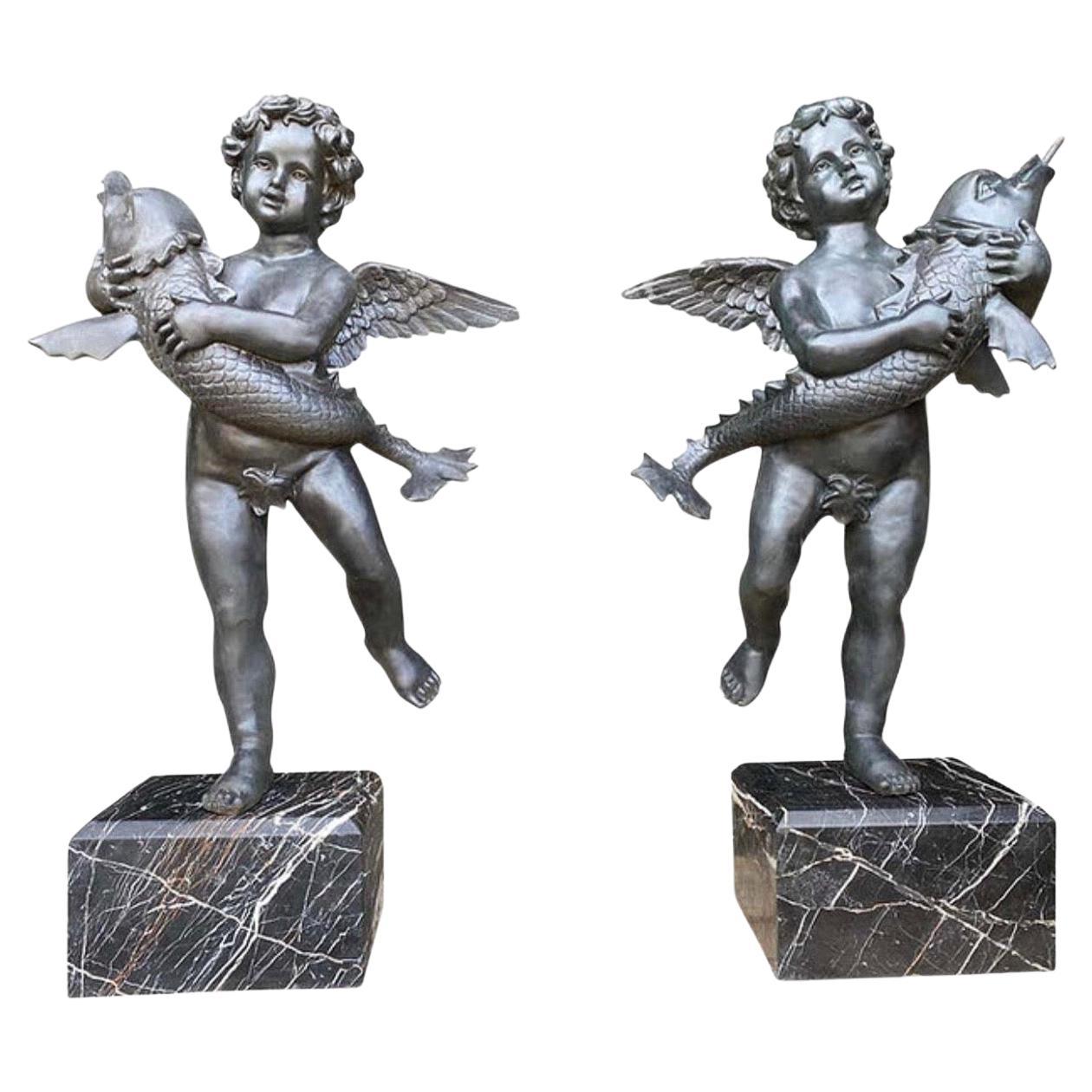 A large impressive pair of 20th century bronze Cherub fountains with fish. Situated on Verdi Antico marble bases. This pair are fully functional working fountains, perfect for garden use and ponds.