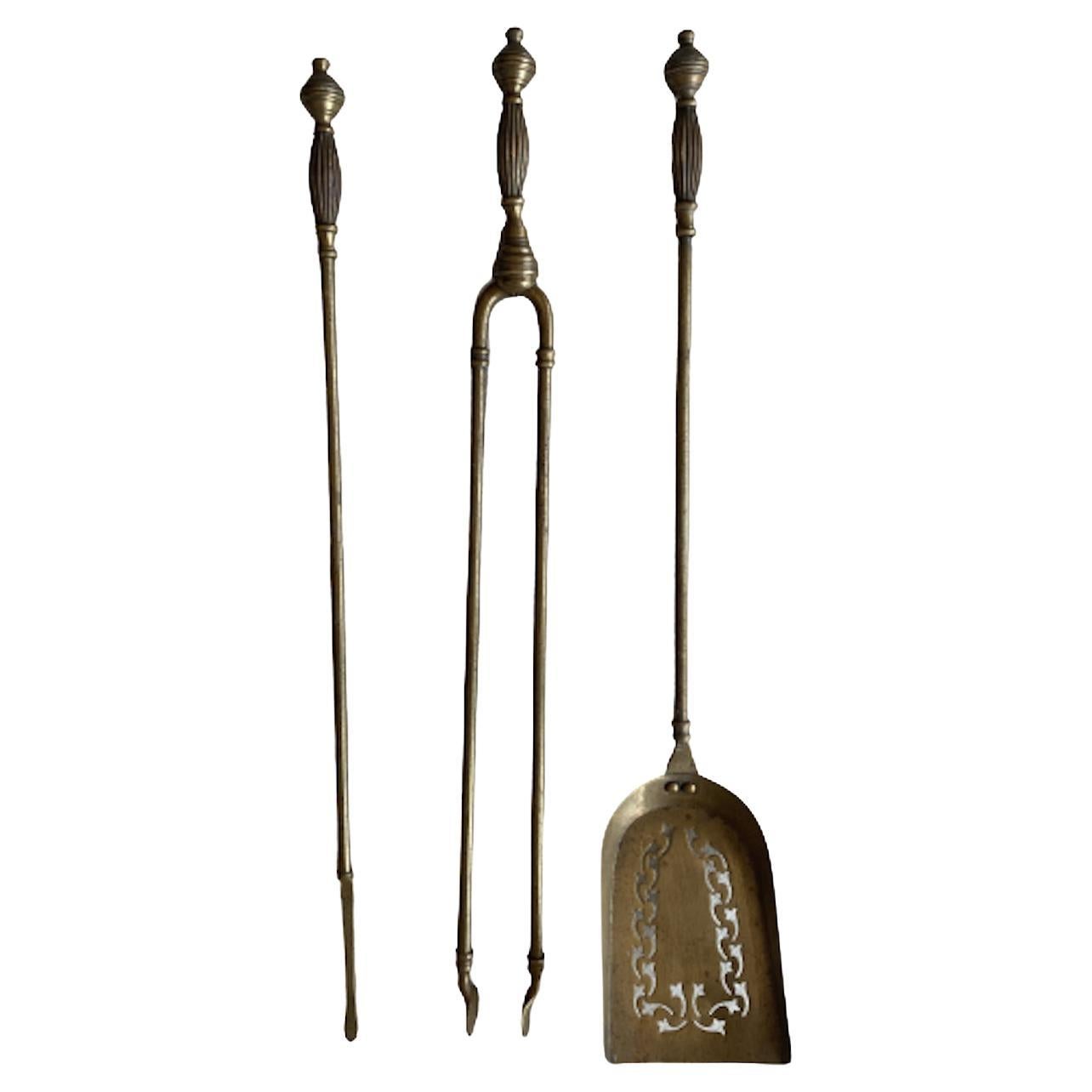 A stunning antique Victorian Gothic brass fire companion set. The superb set is solid brass, with beautiful motifs and design. The spade is engraved with floral design, matching the elegant yet powerful impression the set provides. This is truly a