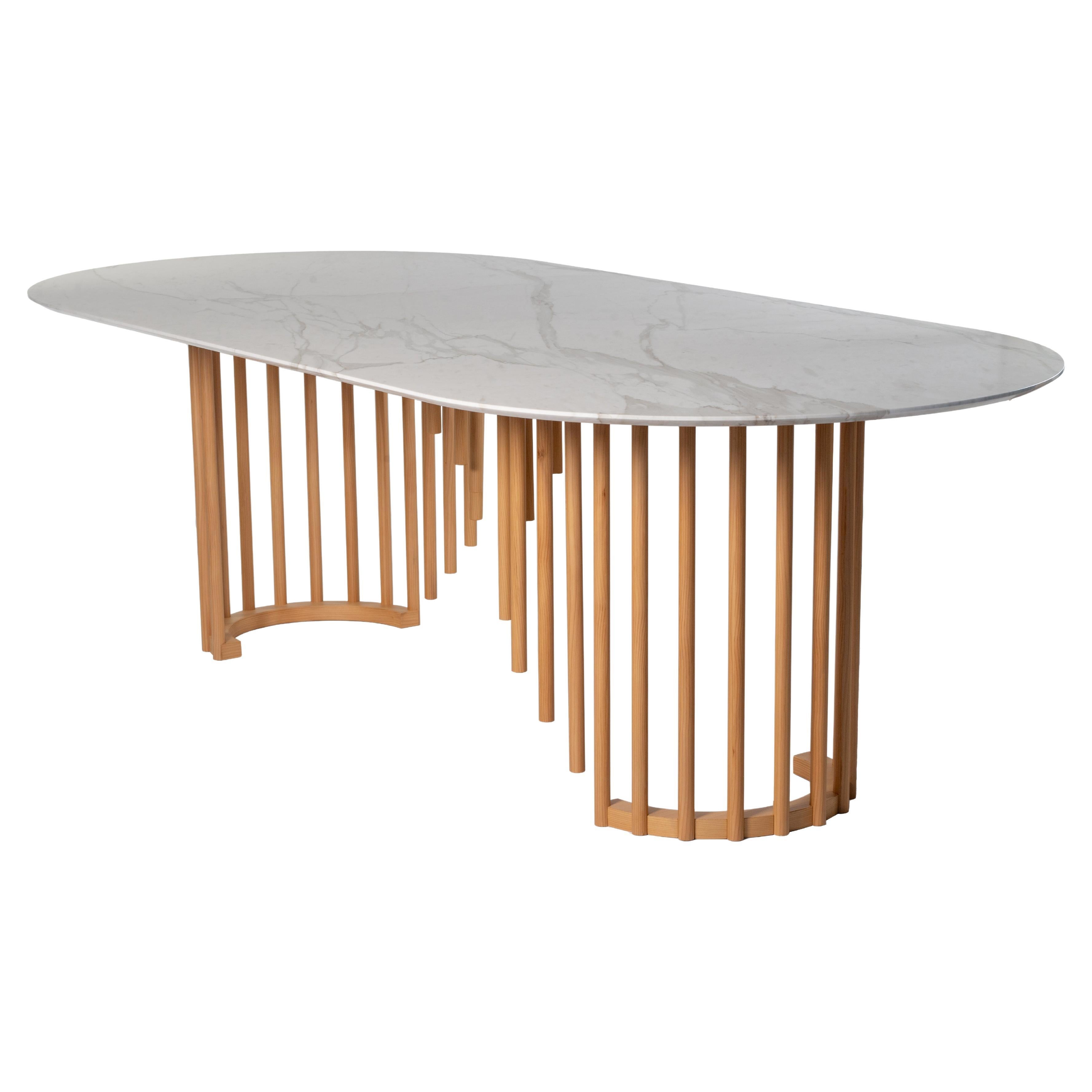 Cette table enchanteresse en cèdre est un hommage à la légèreté naturelle du roseau. Le plateau ellipsoïdal audacieux et lumineux en marbre blanc Calacatta est gracieusement soutenu par les éléments en forme de roseau de différentes longueurs qui
