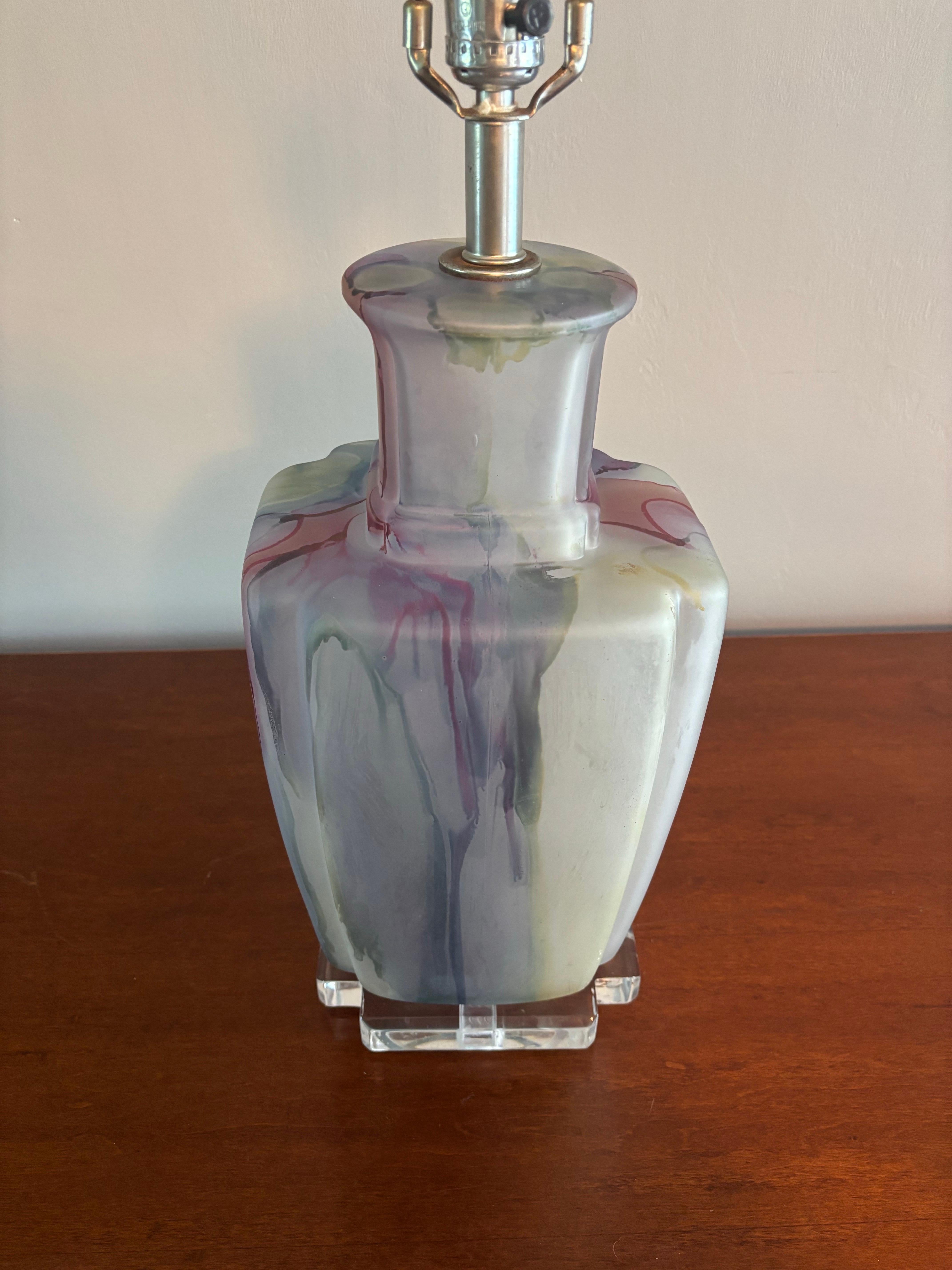 Fantastic Mid century modern Bauer table lamp. Classic French/European shape with broad shoulders and mild lipped accents adorning the silhouette of the glass portion. Containing a beautiful array of deep merlot reds, blues and some yellow/green in