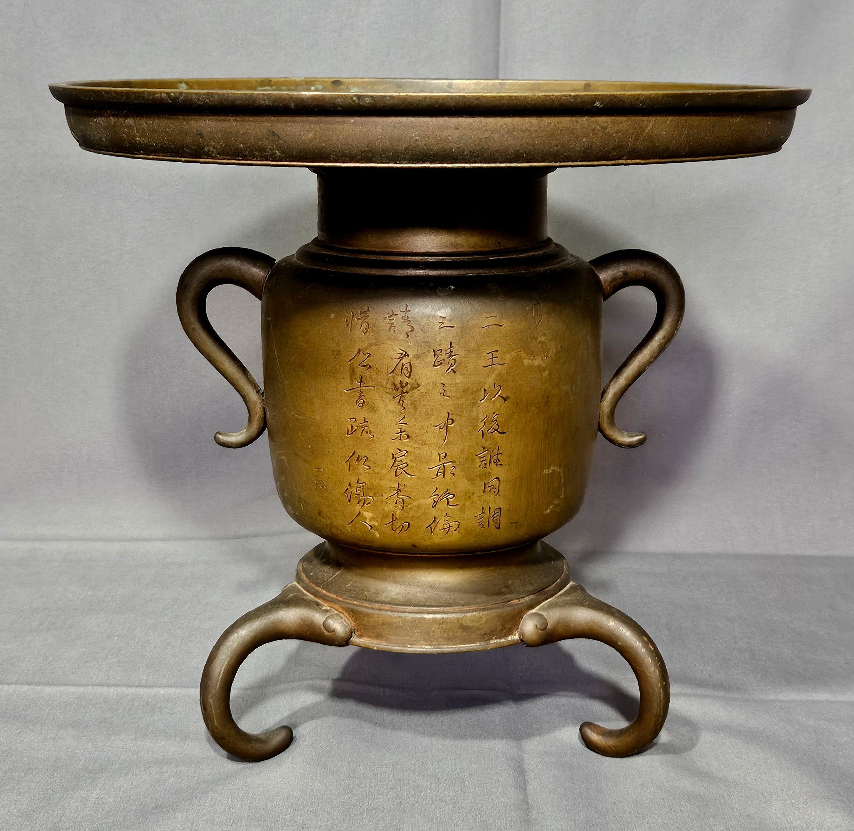 VASO TRIPODE GIAPPONESE IN METALLO MISTO DEL XIX SECOLO
Vaso Usubana/Ikebana in bronzo del periodo Meiji in due parti, con parte superiore a forma di disco rimovibile, due manici ad anello e gambe a treppiede applicate, la parte anteriore decorata