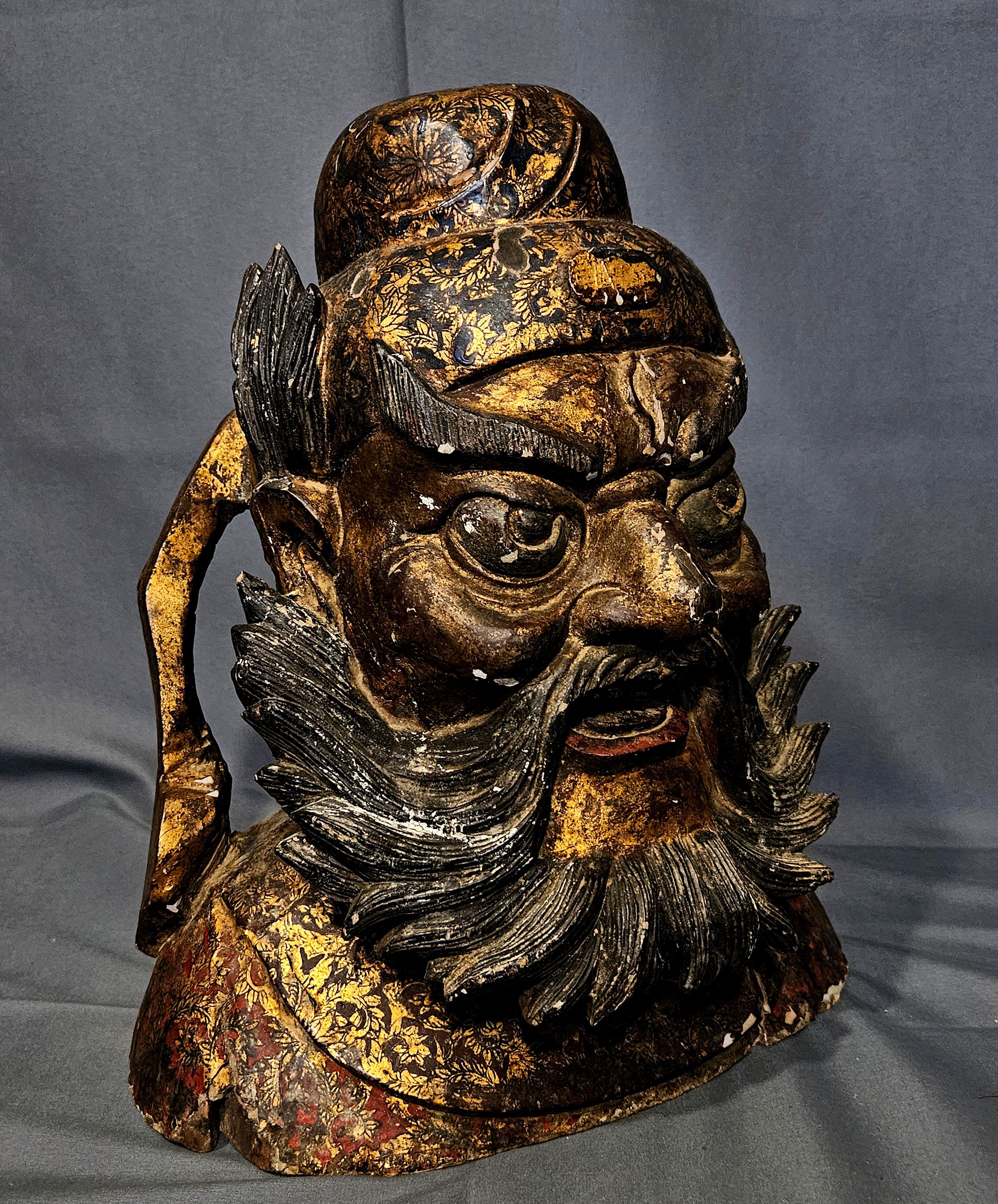 Grande tête en bois sculpté. Chine. 18e/19e siècle. Image de Kuan Ti. Surface laquée en rouge et or avec des volutes florales. 14.5 