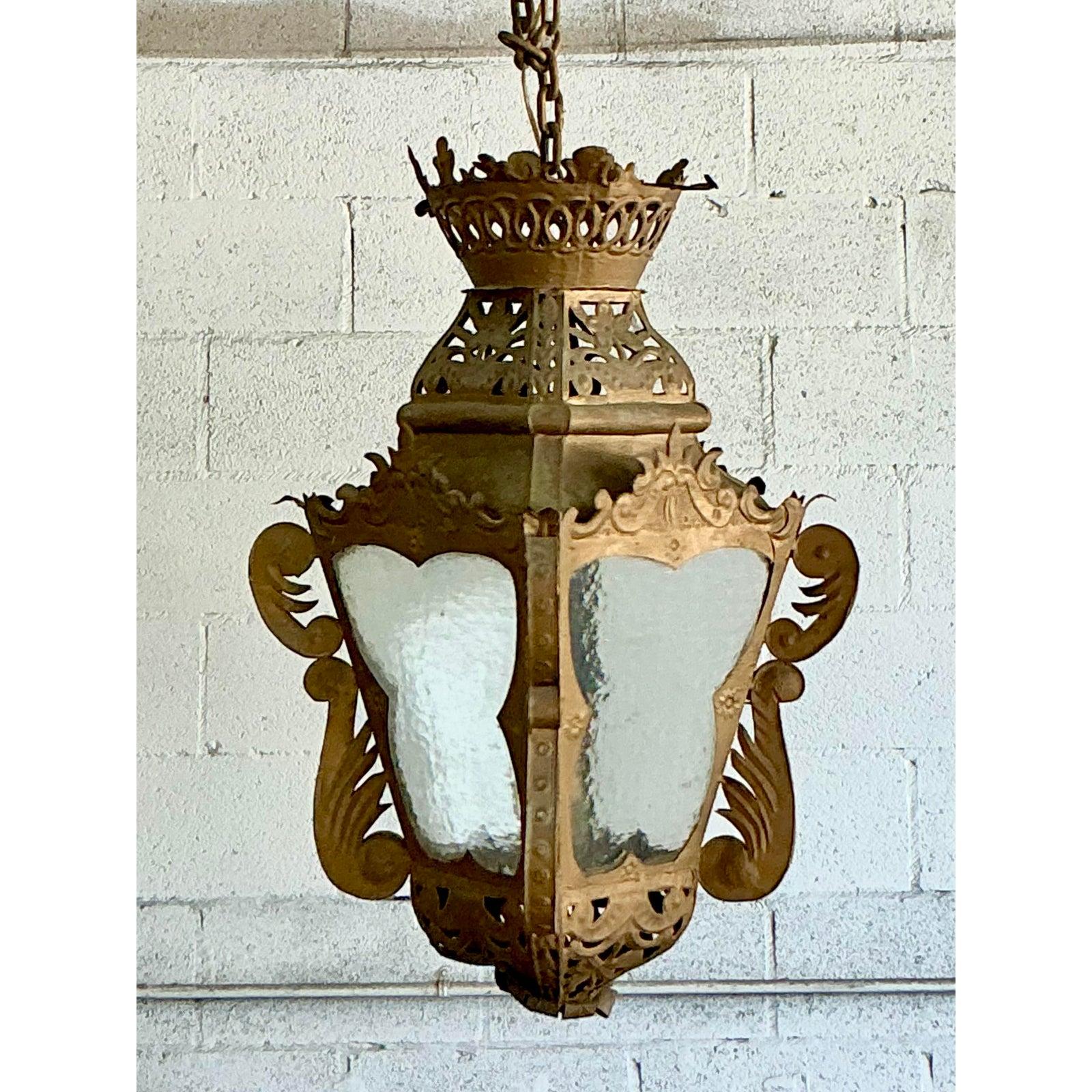 Illuminate your space with the captivating allure of this vintage pierced metal lantern, a true embodiment of bohemian elegance. Its ornate design features exquisite pierced metalwork and graceful scrolling details, showcasing a remarkable level of