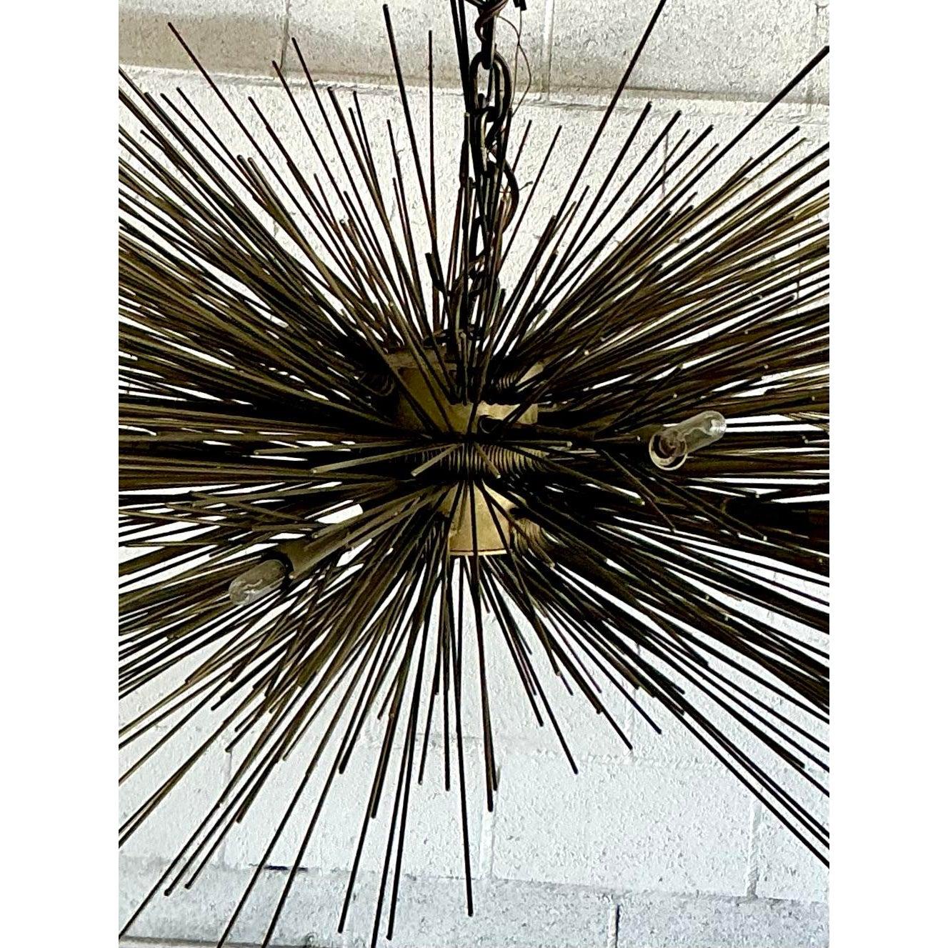 Fai una dichiarazione mozzafiato con questo lampadario Sputnik vintage davvero monumentale, un'incredibile testimonianza del design del Mid-Century. Questo accattivante apparecchio esplode con un'impressionante serie di sottili punte di metallo