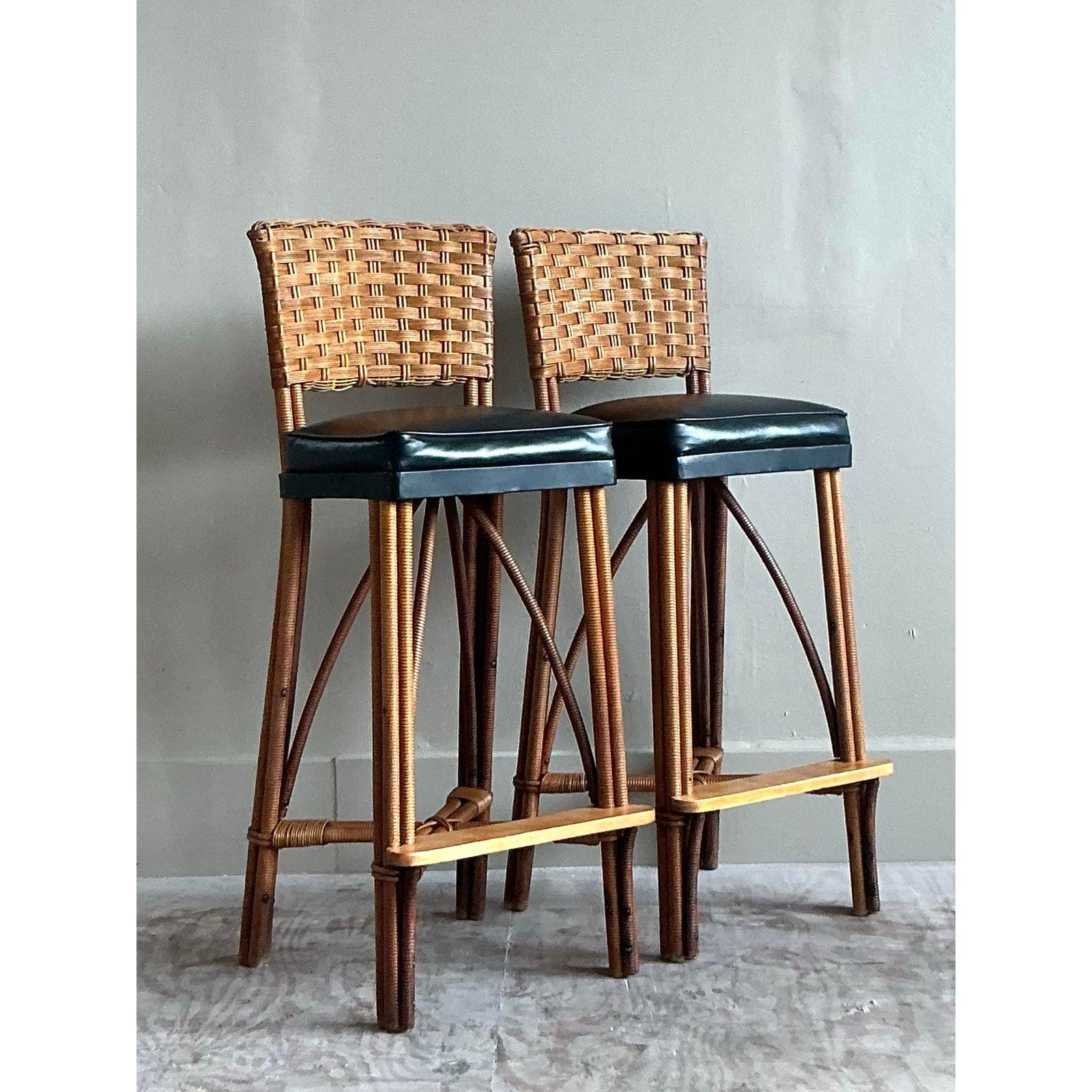Embrace a timeless organic modern aesthetic with this handsome pair of vintage wrapped rattan bar stools. Expertly crafted, each stool features a substantial frame meticulously wrapped in rattan, creating incredible texture and visual depth. The