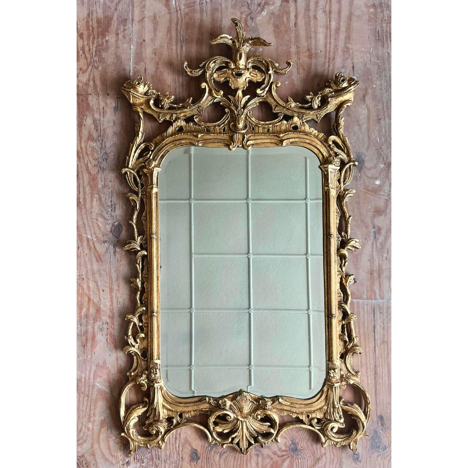 Exhalant une opulence pure et un flair théâtral, ce magnifique miroir doré vintage est un chef-d'œuvre du design néo-rococo. Le cadre monumental est somptueusement sculpté à la main avec des volutes élaborées en C, des feuilles d'acanthe et une