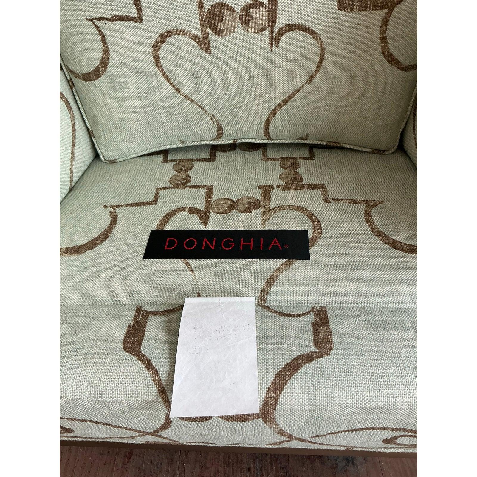 A masterful blend of classic form and modern sophistication, this dramatic pair of wingback chairs from the renowned house of Donghia makes an unforgettable statement. The chairs feature a dramatic, tall wingback silhouette that offers both an