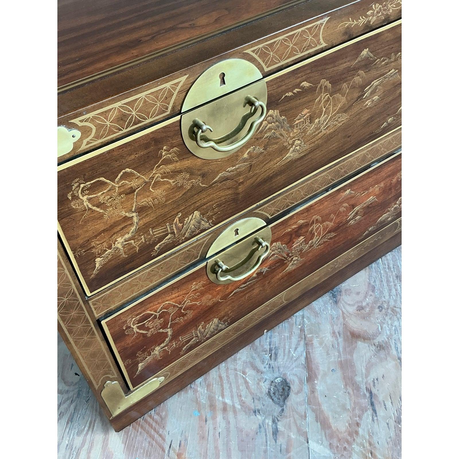 A stunning example of Drexel's mastery, this vintage Chinoiserie chest beautifully marries classic English campaign style with exotic Asian artistry. The body is crafted from rich, luminous mahogany, elegantly framed by delicate inlay that