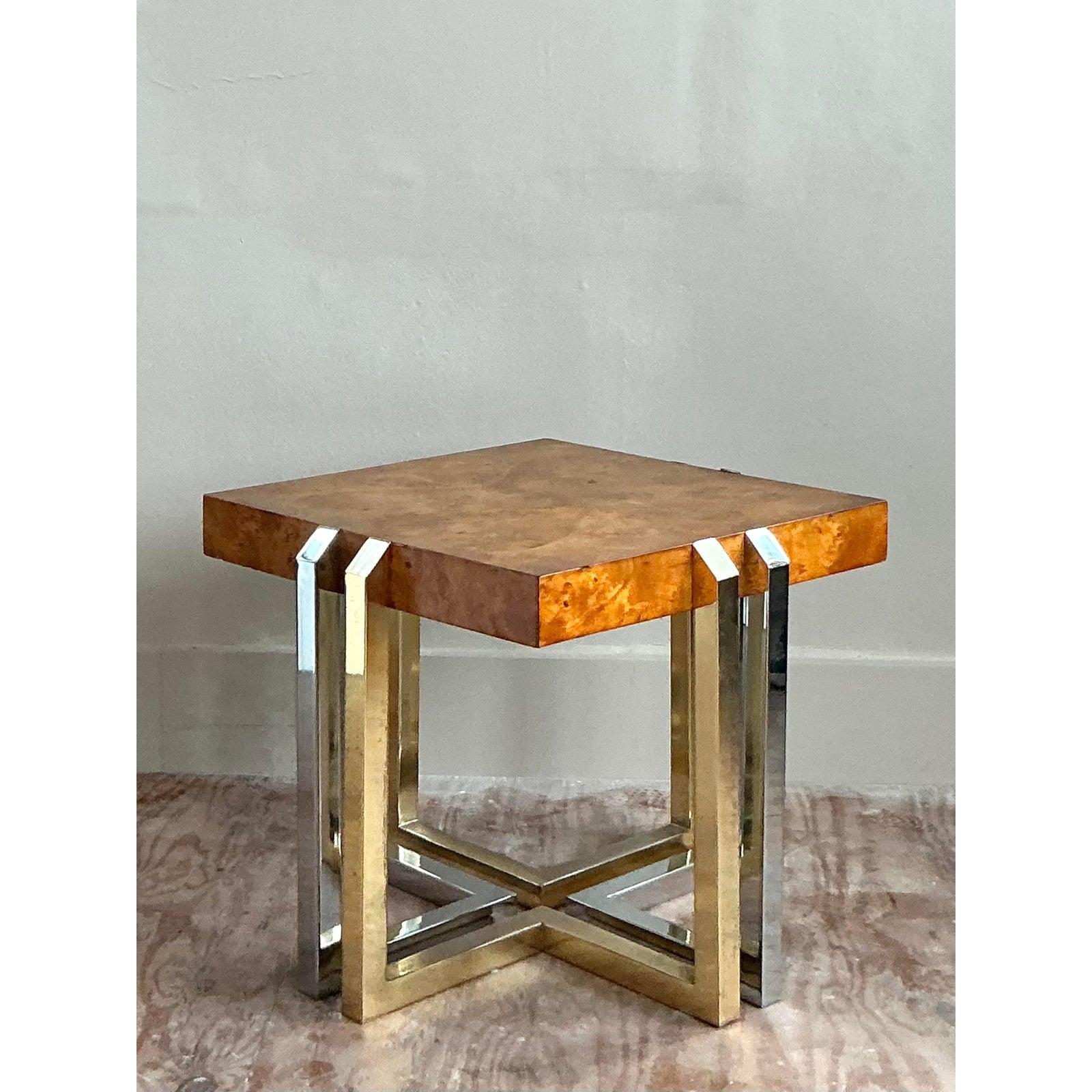 Questo tavolino vintage è un connubio straordinario di calore organico e glamour elegante, una masterclass nello stile del designer degli anni Settanta. Il pezzo forte è lo squisito piano in legno di radica abbinato, che presenta una venatura ricca