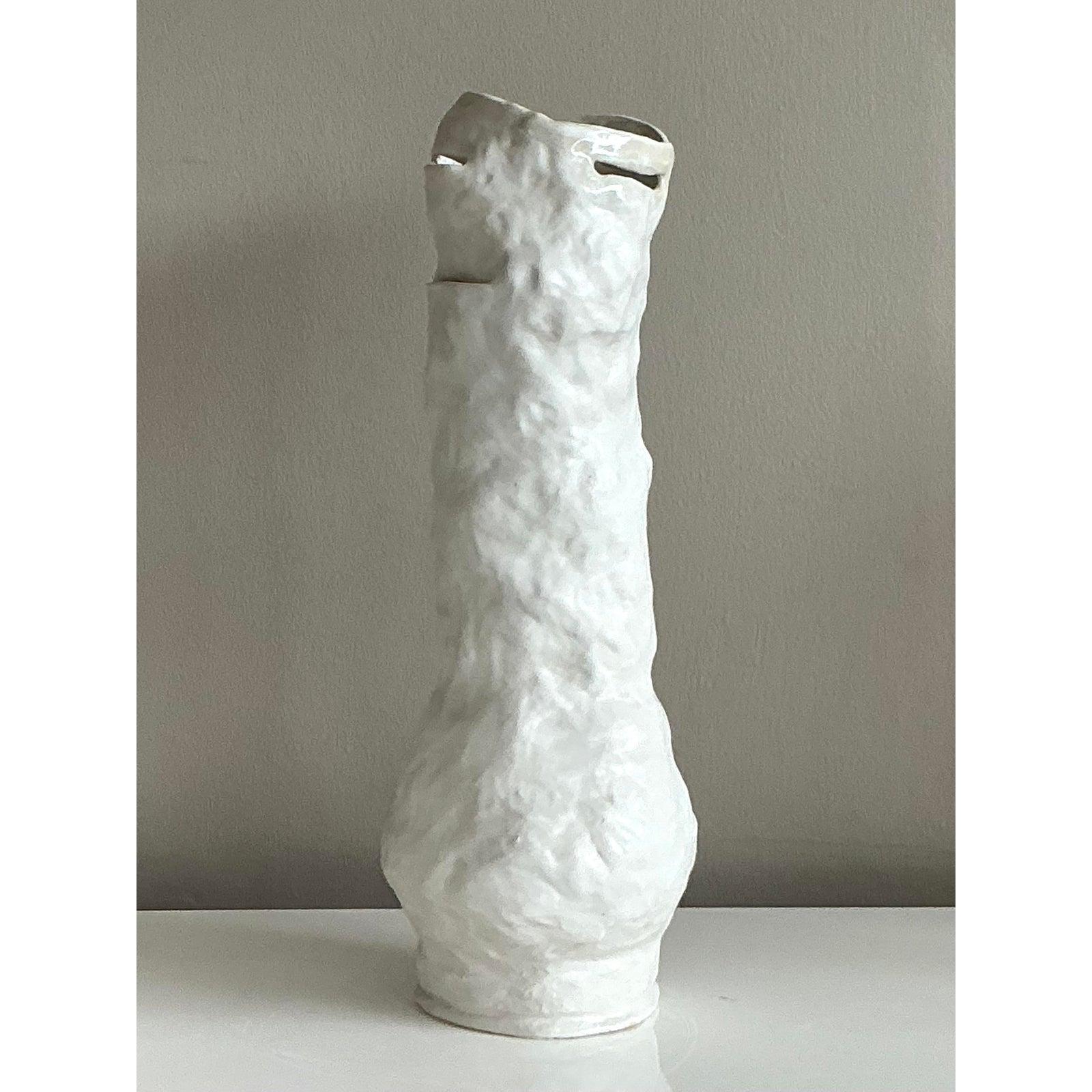 Esempio straordinario di Studio Pottery di ispirazione brutalista, questo vaso alto e originale è una testimonianza della bellezza della forma e della consistenza grezza. Sapientemente costruito a mano, il vaso presenta una superficie fortemente