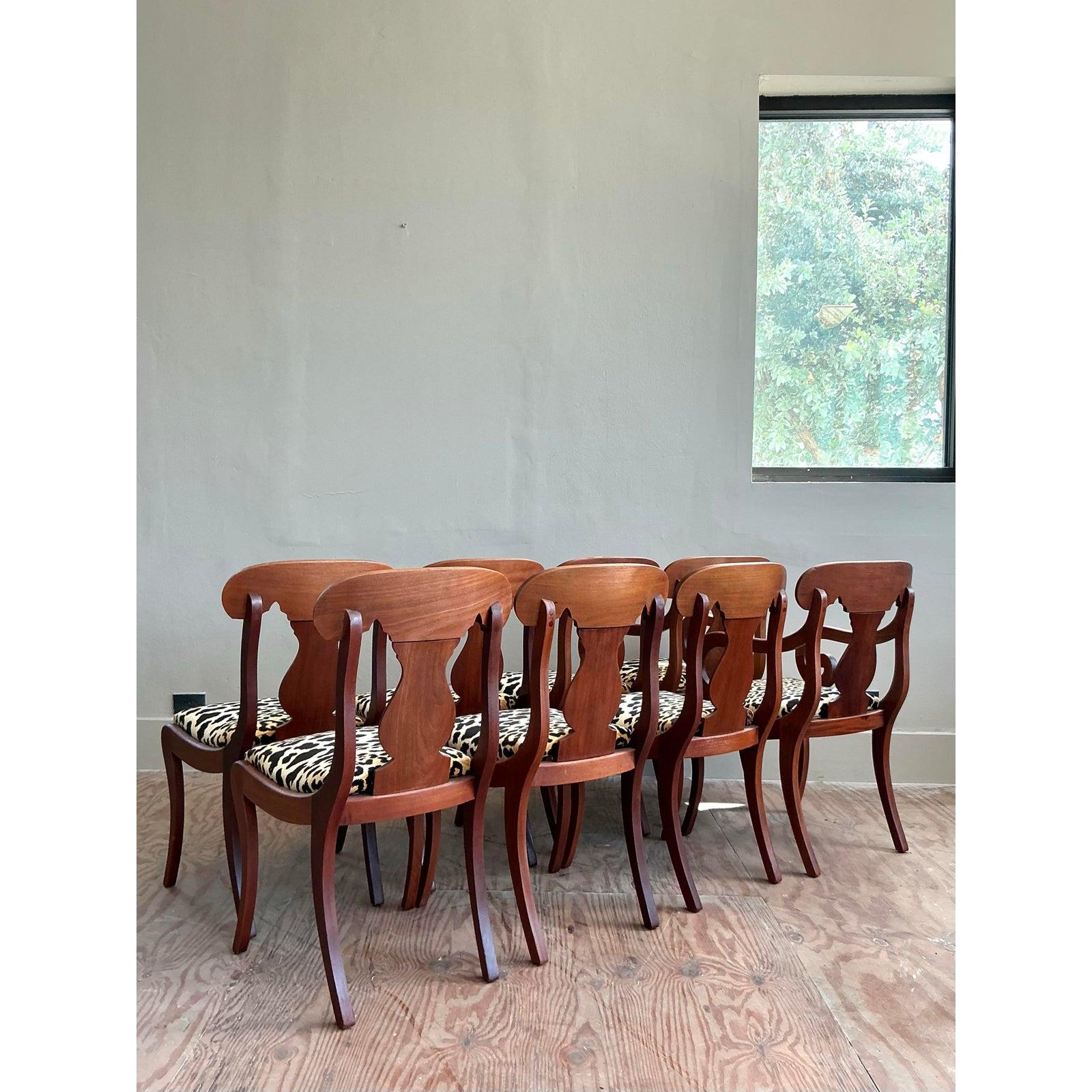 Command attention at your next dinner party with this spectacular set of eight vintage dining chairs, showcasing an exquisite blend of Regency-era elegance and bold, contemporary flair. Crafted from striking flame mahogany, each chair boasts a rich,