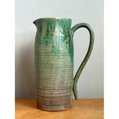 Cruche vintage en poterie d'atelier, de couleur verte, fabriquée à la main