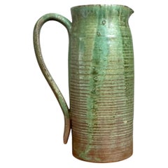 Cruche vintage en poterie d'atelier, de couleur verte, fabriquée à la main