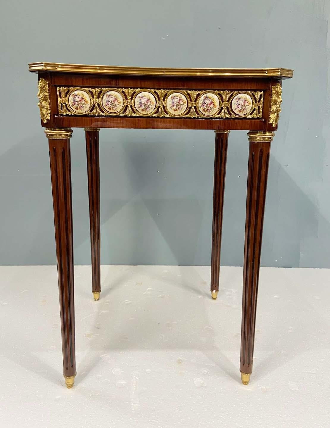 Vous voyez ici une magnifique paire de tables d'appoint françaises de style Louis XVI.
Les plateaux présentent une marqueterie exquise, avec des motifs floraux et feuillus enroulés, entourés d'une bordure complexe.
Le fond en parquet ajoute une