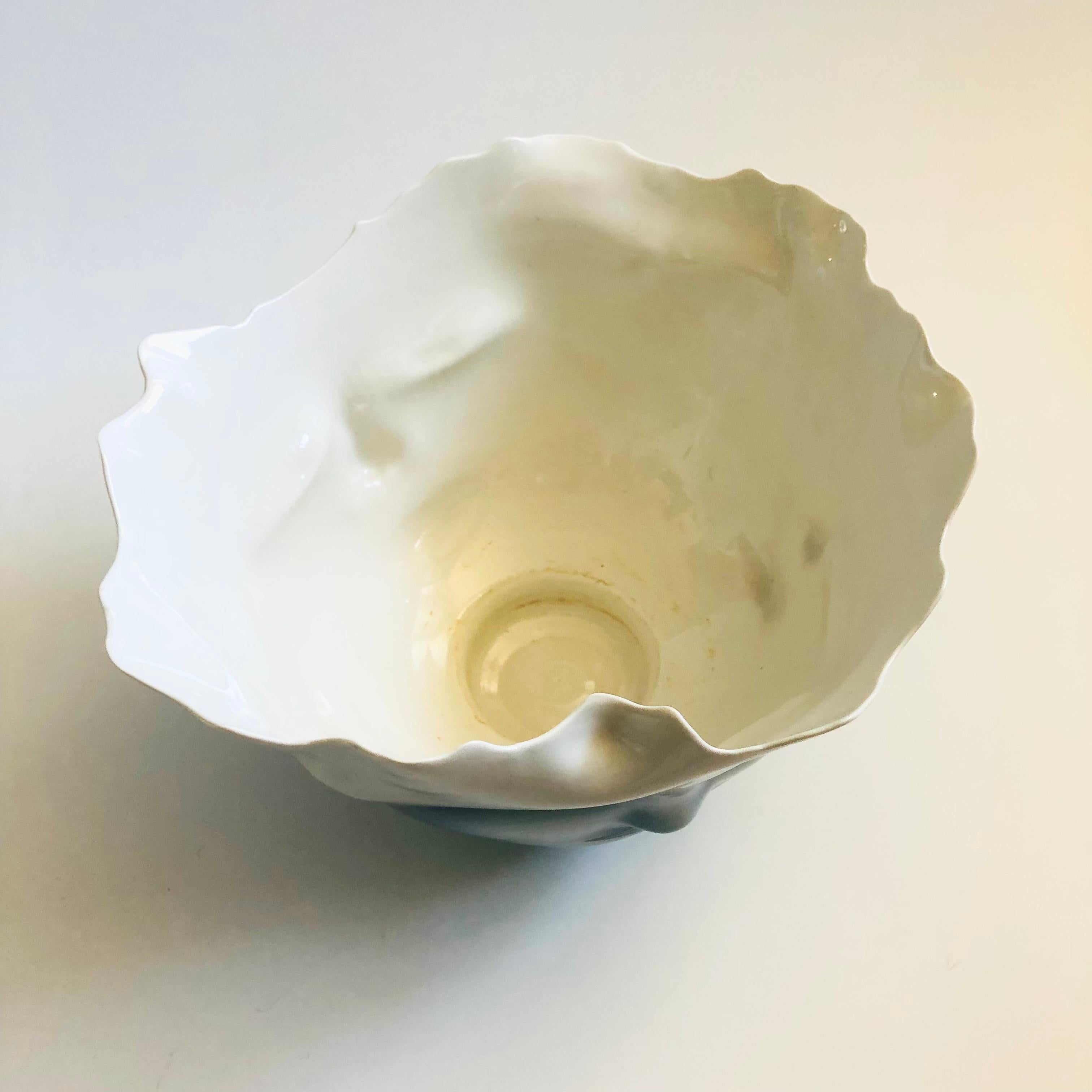 Una grande ciotola in porcellana artistica del ceramista californiano Bing Gleitsman. Presenta un disegno di quattro facce tridimensionali lungo i lati con un bordo dalla forma organica. Smalti lucidi bianchi e grigio-blu con oro metallico alla