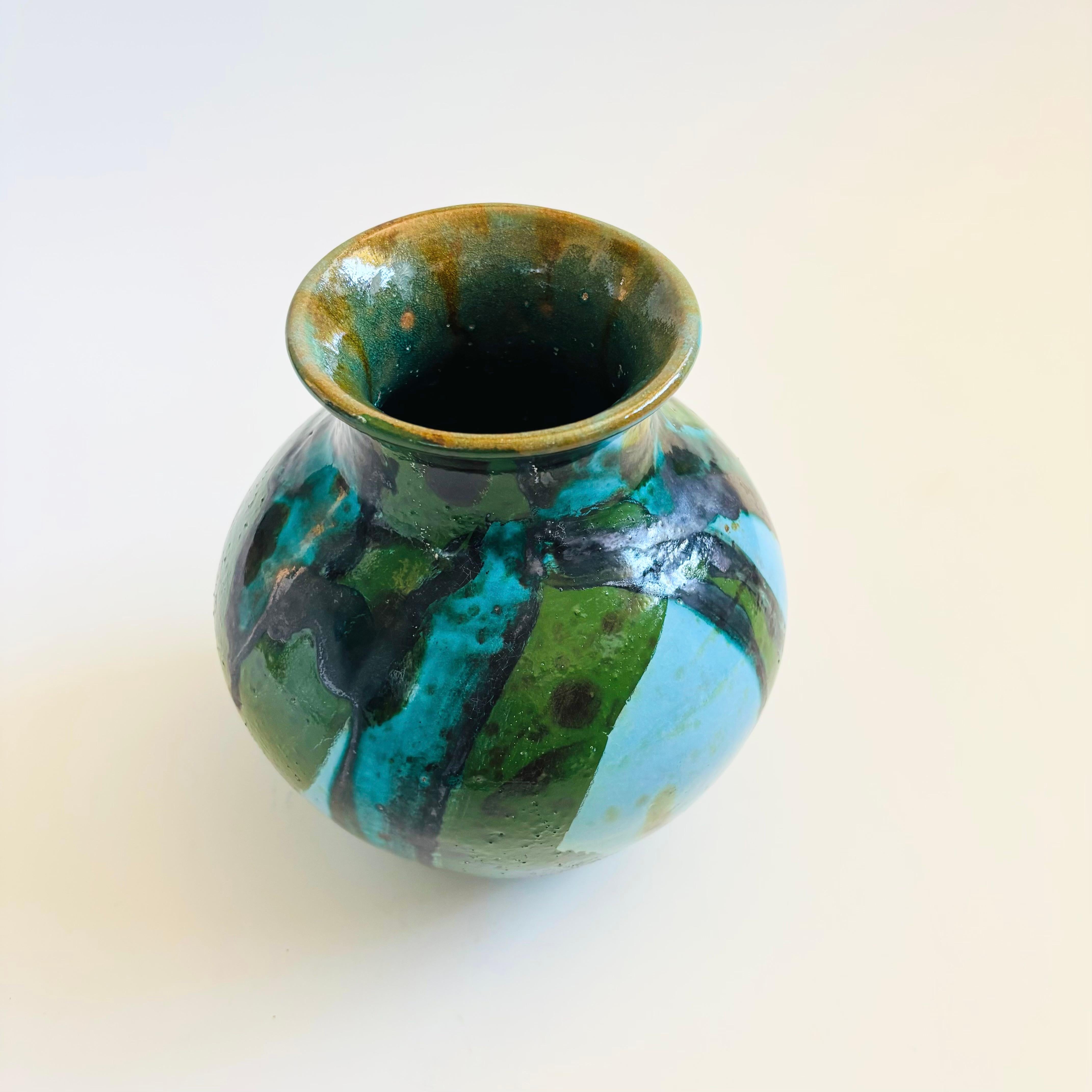 A vintage studio pottery vase with beautiful painted design of overlapping blue and green glazes.

