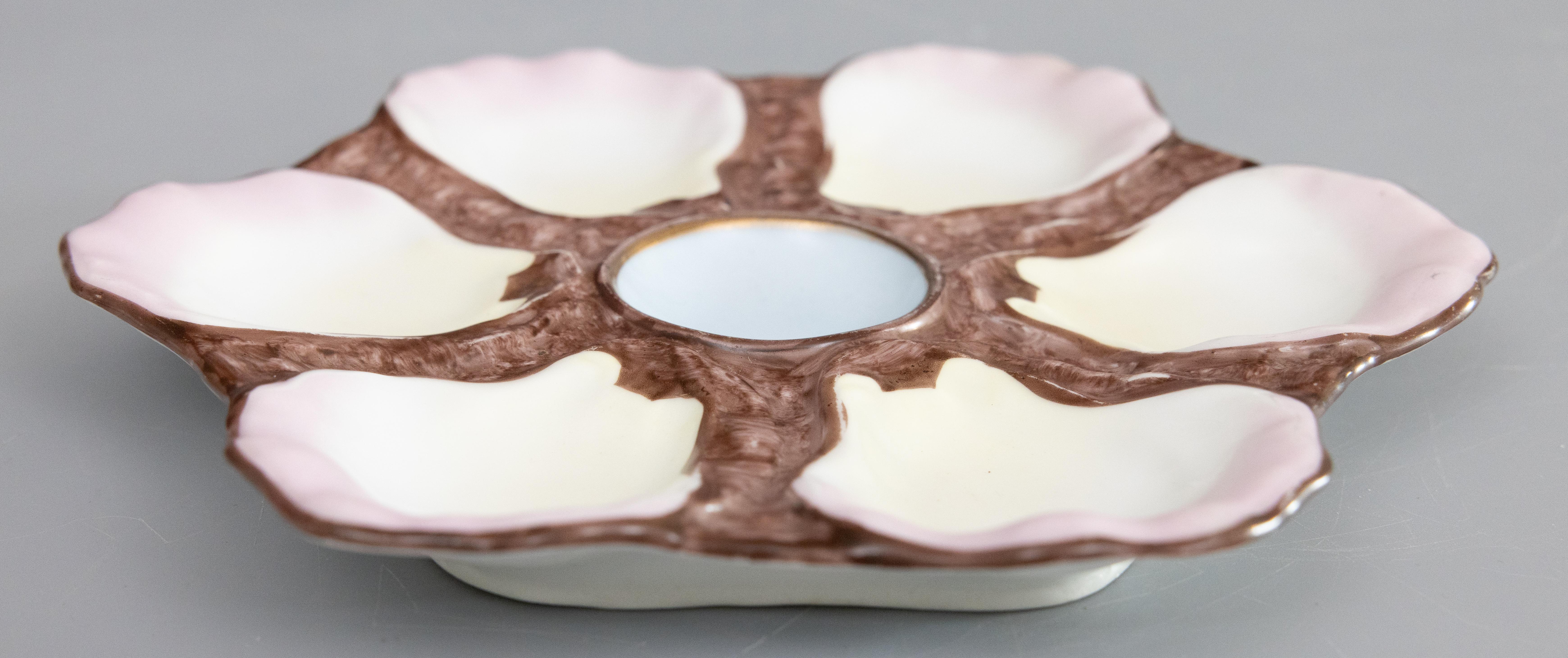 Magnifique assiette à huîtres en porcelaine majolique française du XIXe siècle. Cette assiette à huîtres de qualité supérieure comporte six godets avec une belle teinte rose sur les bords et un centre bleu doux sur un fond brun chocolat. Il se