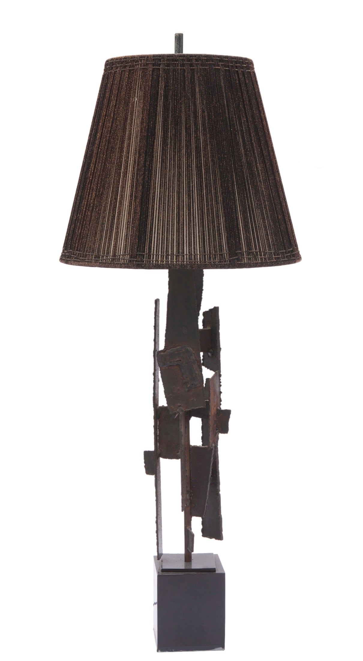 Mid Century Brutalist iron table lamp
Mid-Century Modern Brutalist iron sculptural lamp in black & rust.The sculpture of torch cut steel in a beautiful sculptural form is mounted on a cube. 
Measures: 5