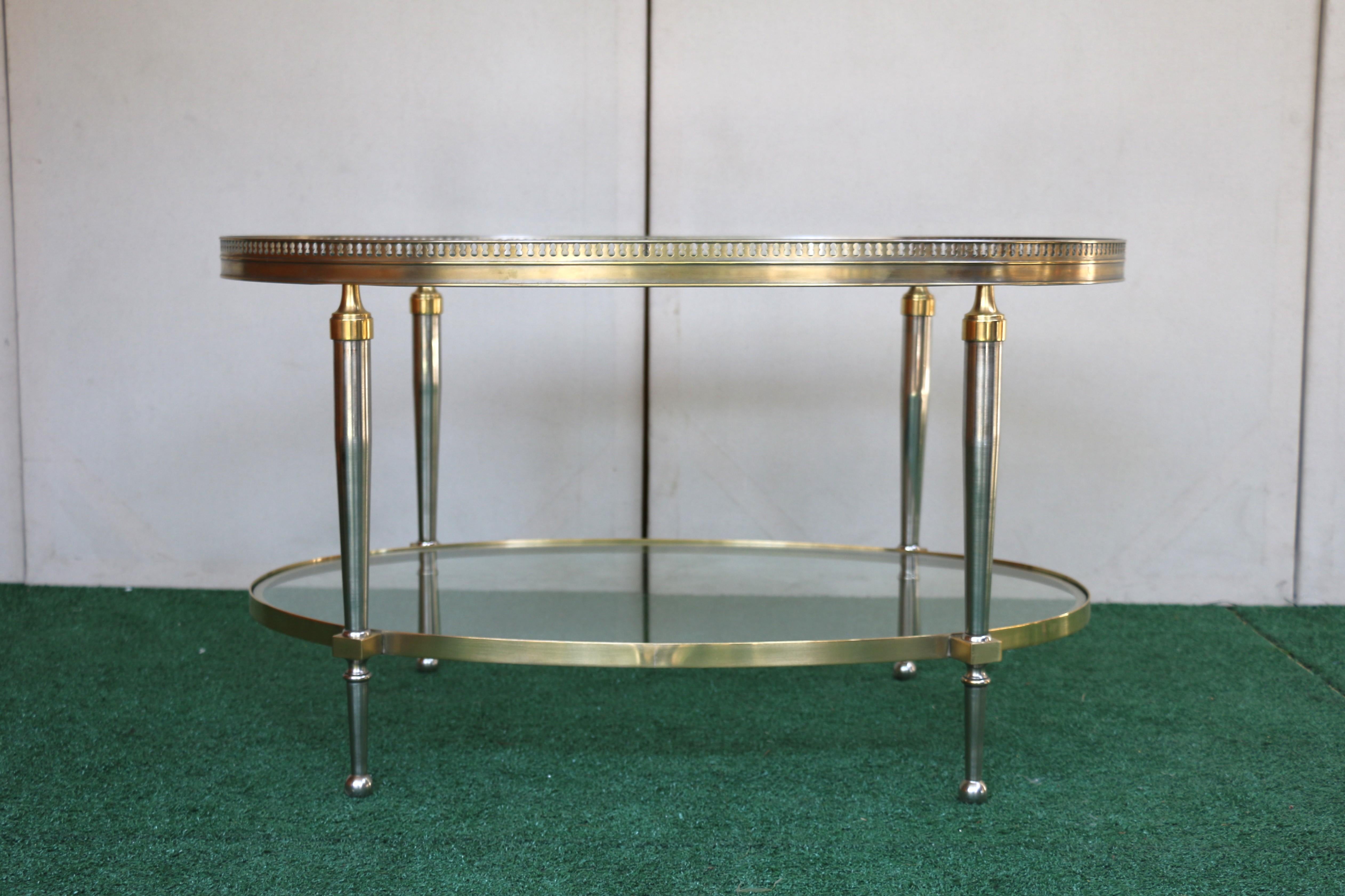Italiano Tavolino da caffè ovale con piano in vetro Trouvailles Hollywood Regency in argento e ottone in vendita