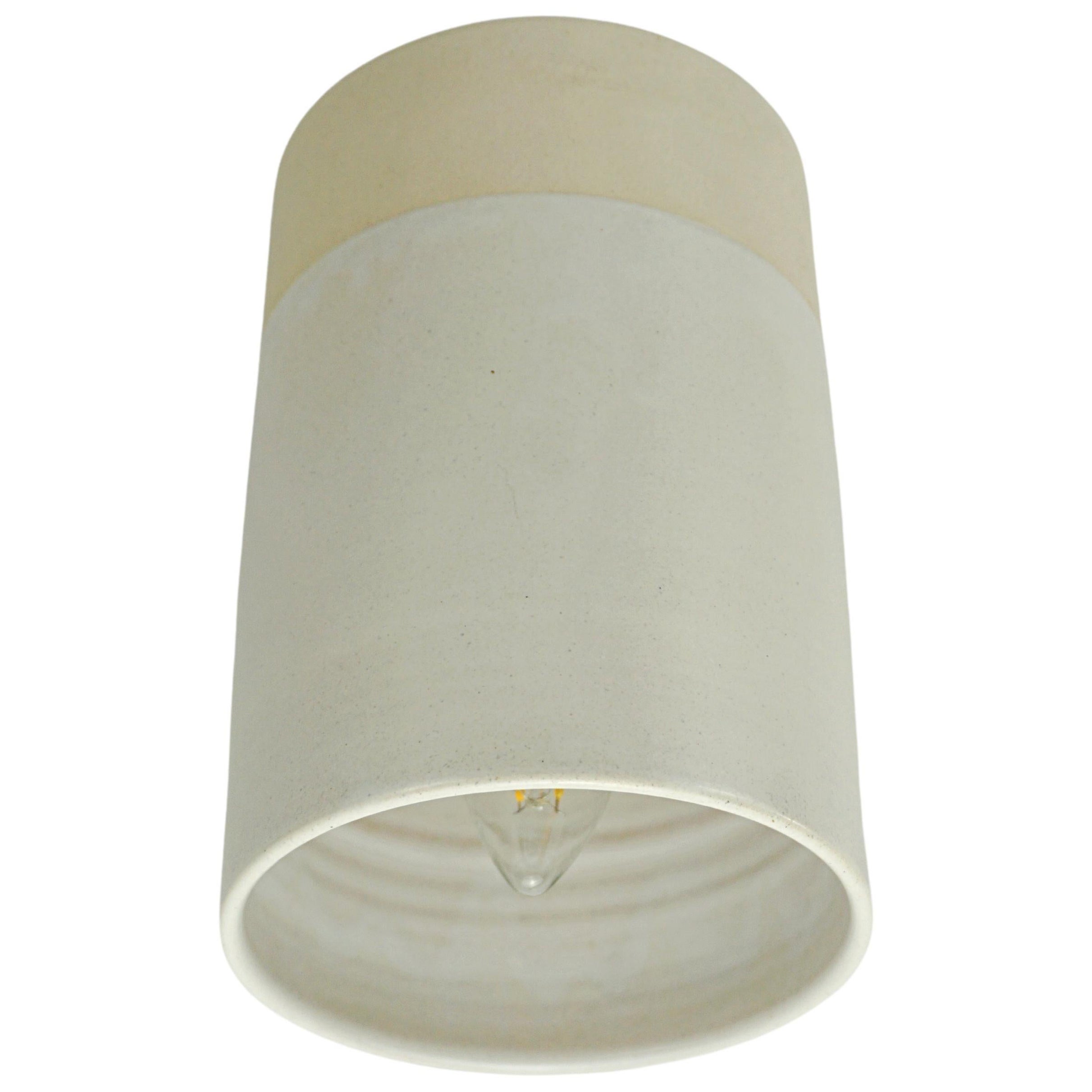 matte off-white wall light made of glazed ceramic, blends in with the wall