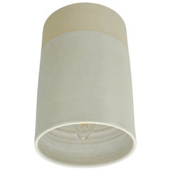 matte off-white wall light made of glazed ceramic, blends in with the wall