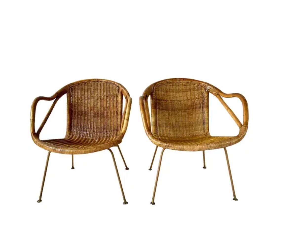 Pair of Iconic Mid-Century Modern Woven Rattan Chairs by Paul McCobb for Calif-Asia Co, circa 1950s. These lounge chairs have a sculptural silhouette featuring a gracefully curved rattan frame with a woven seat and back, highlighting the organic