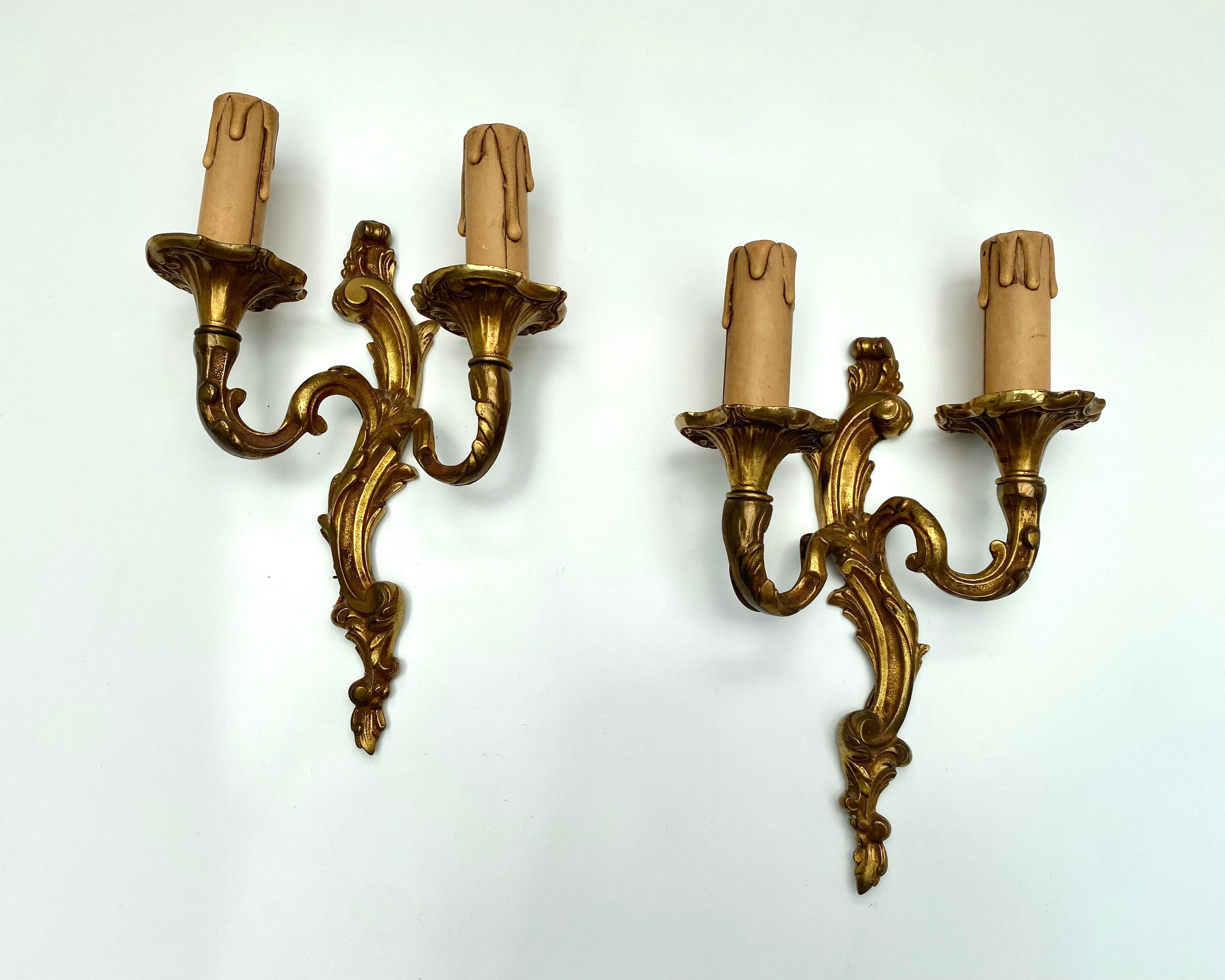 Antiguos apliques de pared franceses, elaborados en el encantador estilo rococó.

Fechados en la primera mitad del siglo XX, estos apliques capturan la elegancia y el arte de una época pasada.

Exquisitamente fabricadas en bronce, presentan