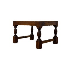 Vintage-Fußhocker aus englischer Eiche mit geflochtener Sitzfläche aus Rattan und gedrechselten Beinen.