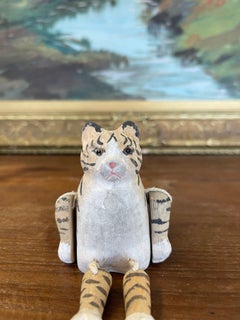 Handgeschnitzte, bewegliche Tiger- oder Katzenfigur aus Holz mit bemalten Details.