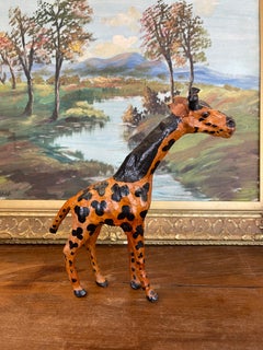Scultura in legno di giraffa intagliata a mano e dipinta, con macchie nere.