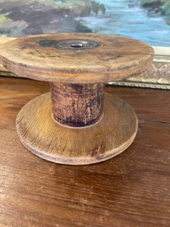 Probabile bobina industriale d'epoca in legno per tessitura, con nucleo probabilmente in ferro.