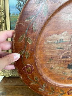 Plato decorativo de madera noruego de época, pintado a mano, que representa a una mujer del pueblo.