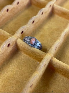 Anillo vintage con un cabujón ovalado de color naranja y detalles de punzonado.