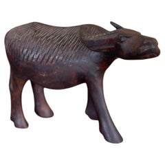 Scultura vintage in legno intagliata a mano raffigurante un bufalo d'acqua, con dettagli in rilievo.