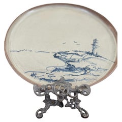 Piatto in ceramica da studio della metà del secolo con scena costiera raffigurante un faro, dipinta a mano.