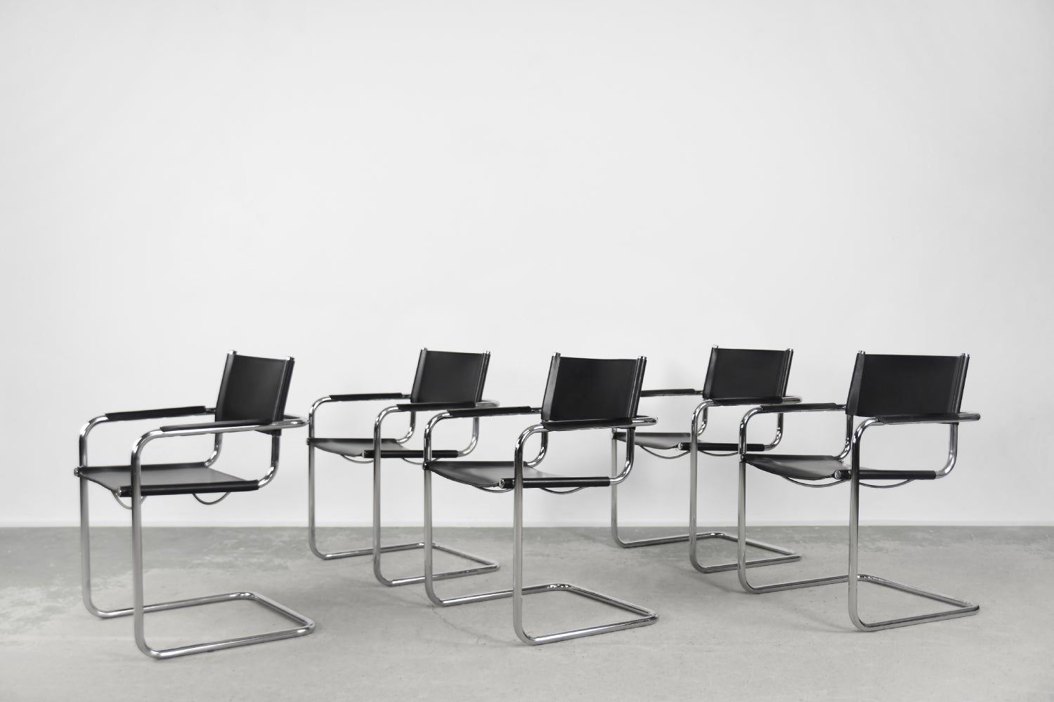 This set of five cantilever chairs was manufactured in Germany during the 1960s. This chairs are made of tubular steel and black natural leather. The cubic form, clear design, and subtle proportions allude to the design of the Bauhaus school, where