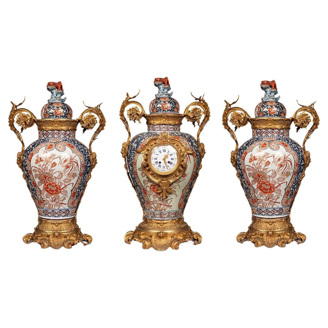 A clock set 3 pieces imari porcelain and bronze